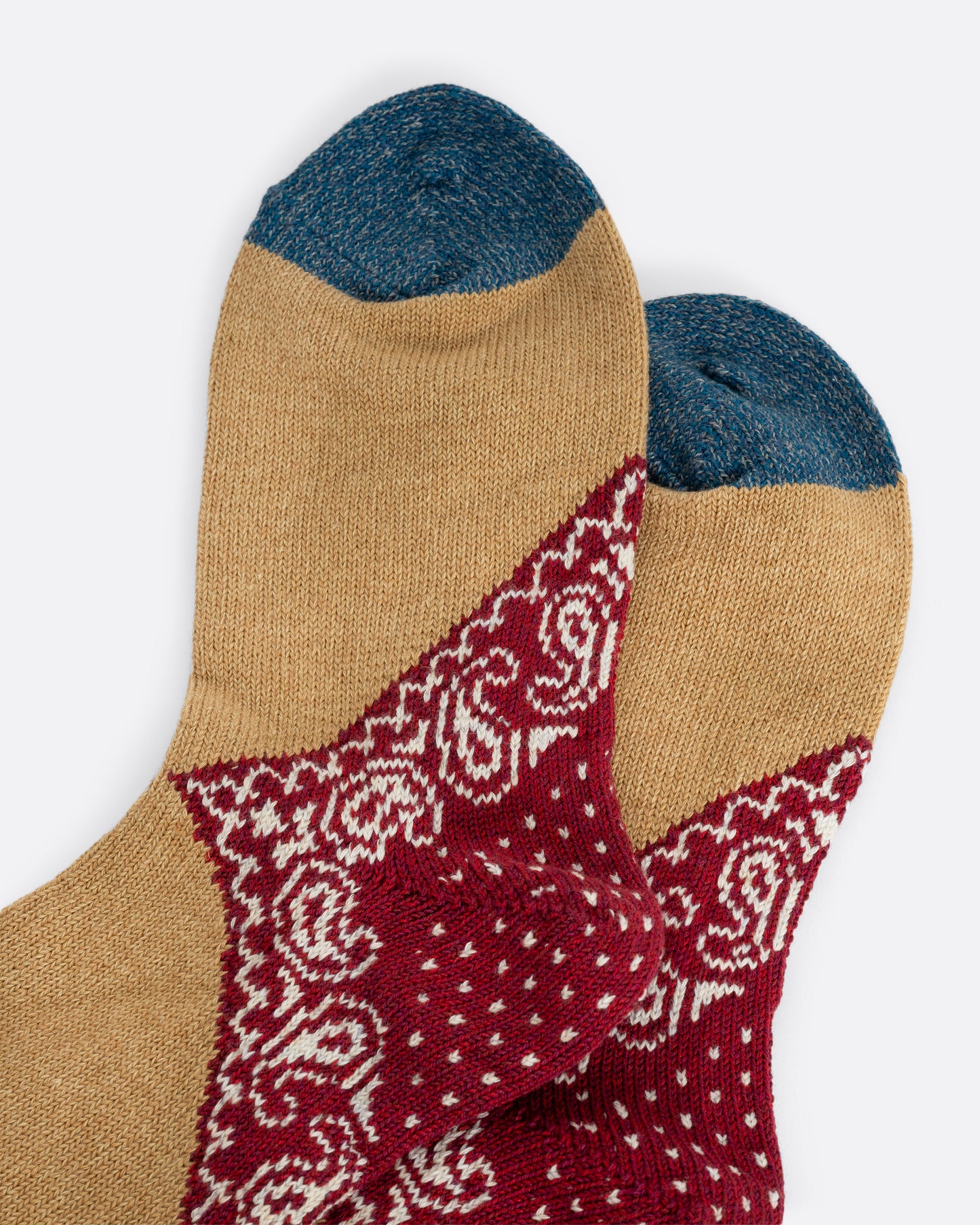 Tan socks with red paisley heels, close up.