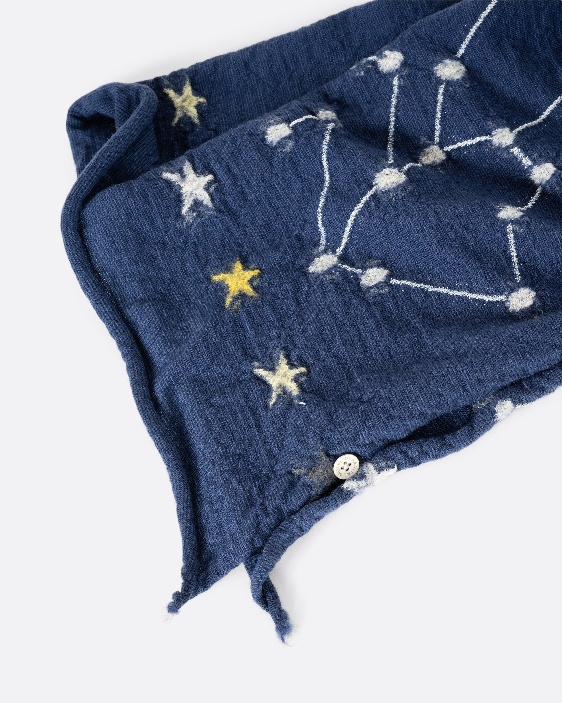 A navy blue scarf with constellations. View of the hem close up.