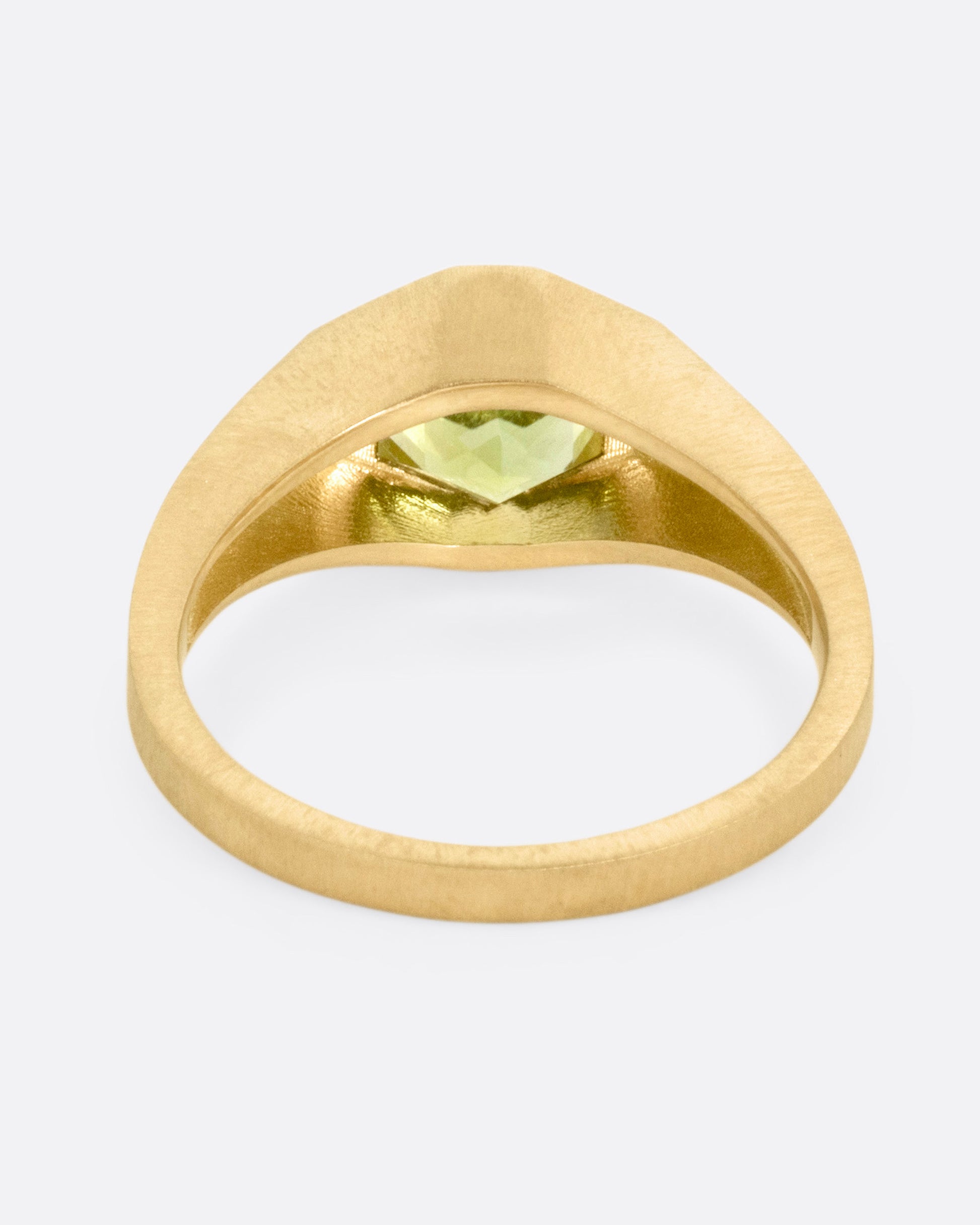 A yellow gold ring with a green hexagonal tourmaline, shown from the back.