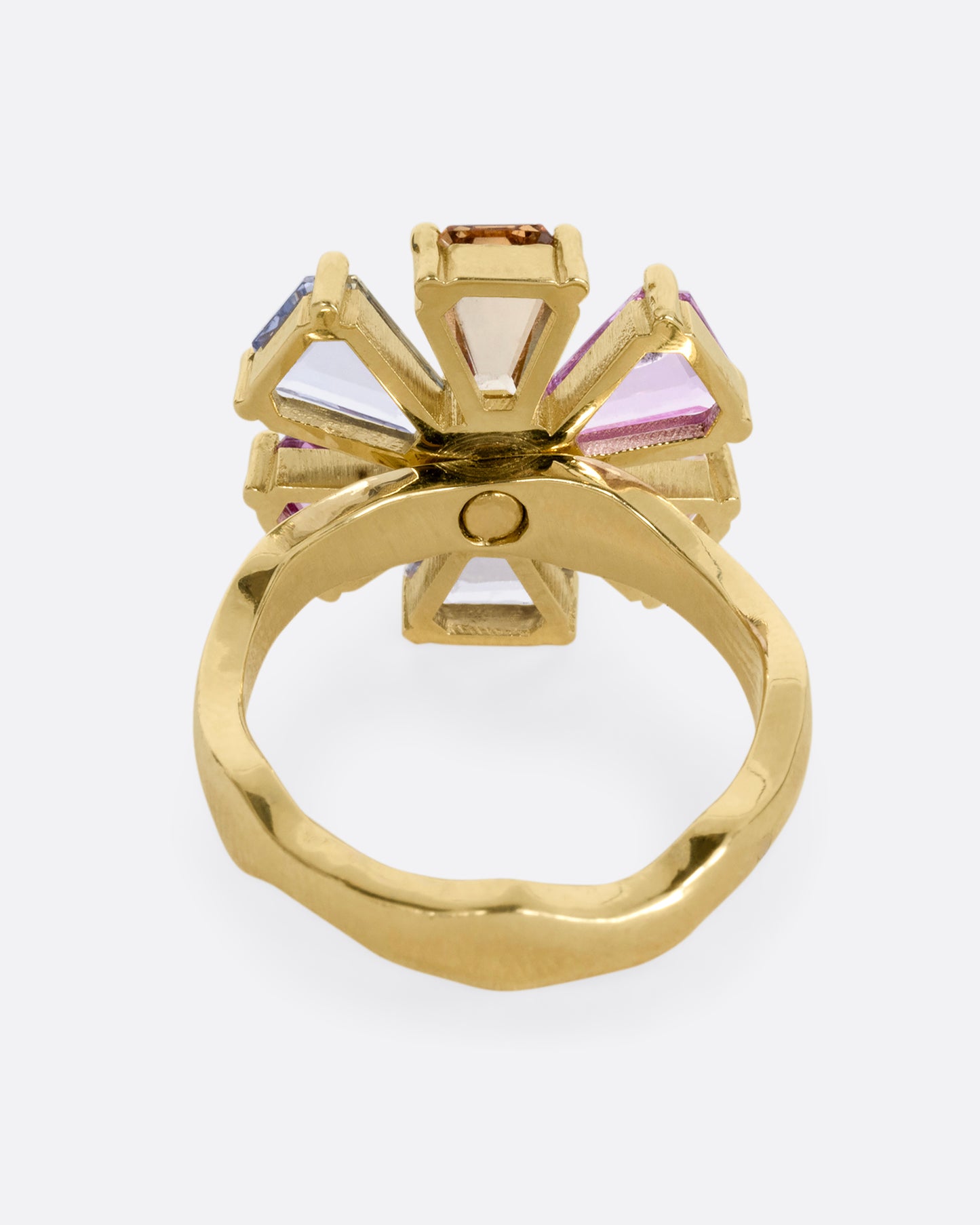 A yellow gold ring with a spinning flower made of multicolor sapphires. Shown from the back.