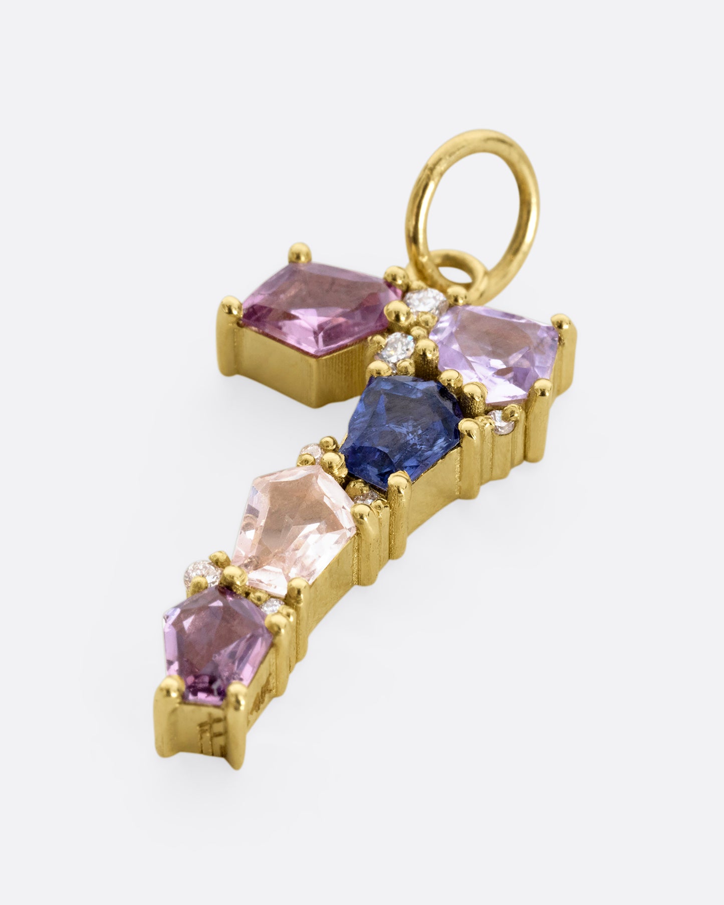 A yellow gold number "7" pendant made of mosaic multicolor sapphires and diamonds. Shown laying flat.