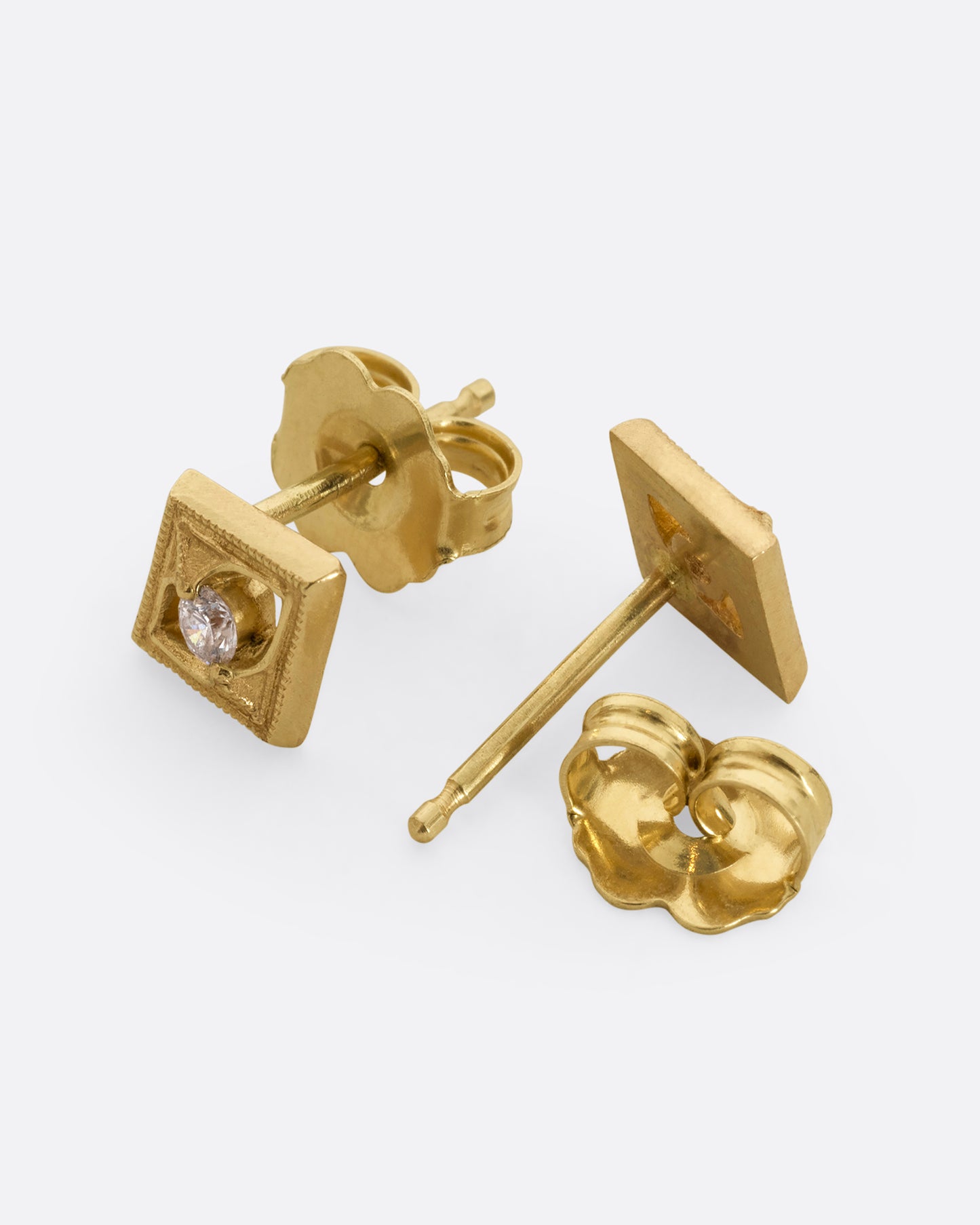 A pair of square yellow gold earrings with round diamonds at the center. Shown from the front and back alternating.