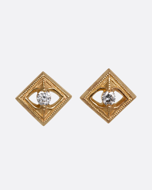 A pair of square yellow gold earrings with round diamonds at the center. Shown from the front.