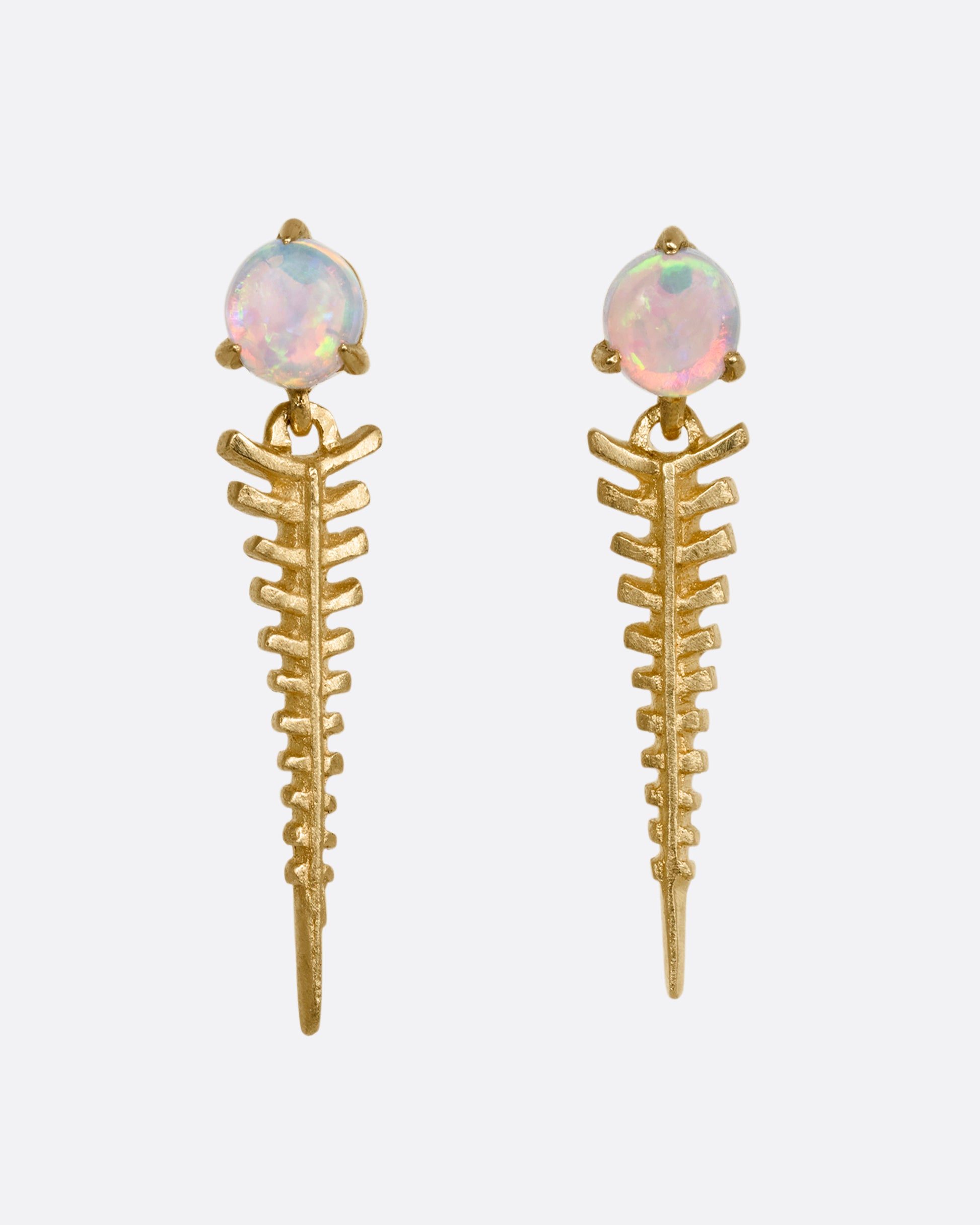 A pair of yellow gold earrings with opal posts and a spine like dangle. Shown from the front.