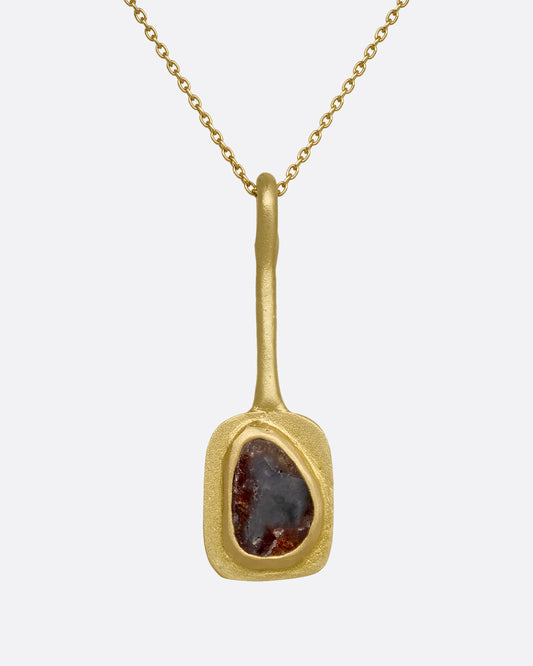 A yellow gold necklace with an ochre diamond pendant, shown close up from the front.