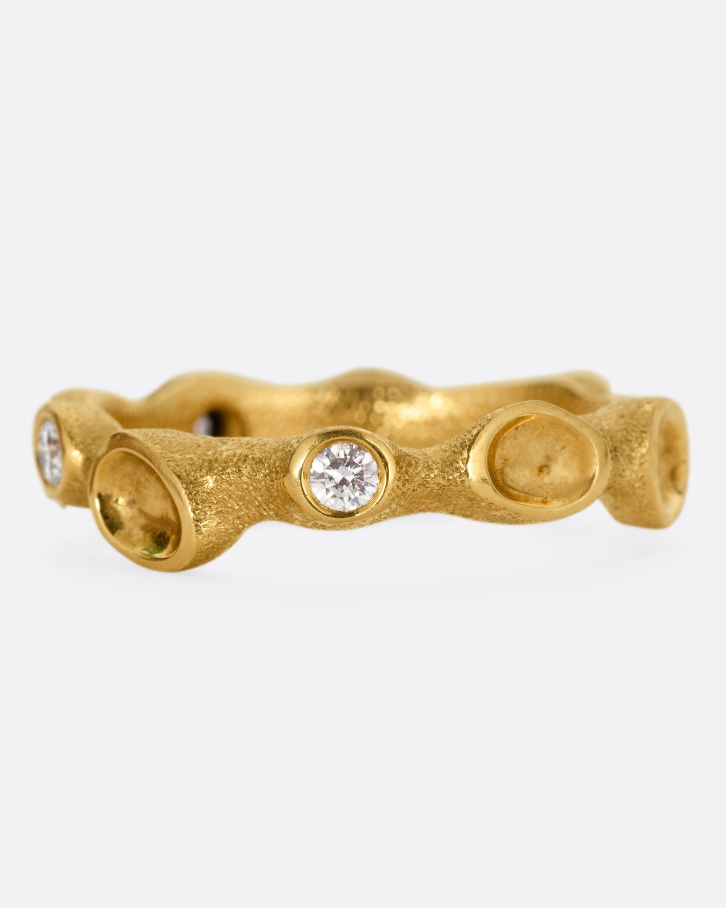 A yellow gold ring resembling a coral reef, with white diamonds, shown from the front.