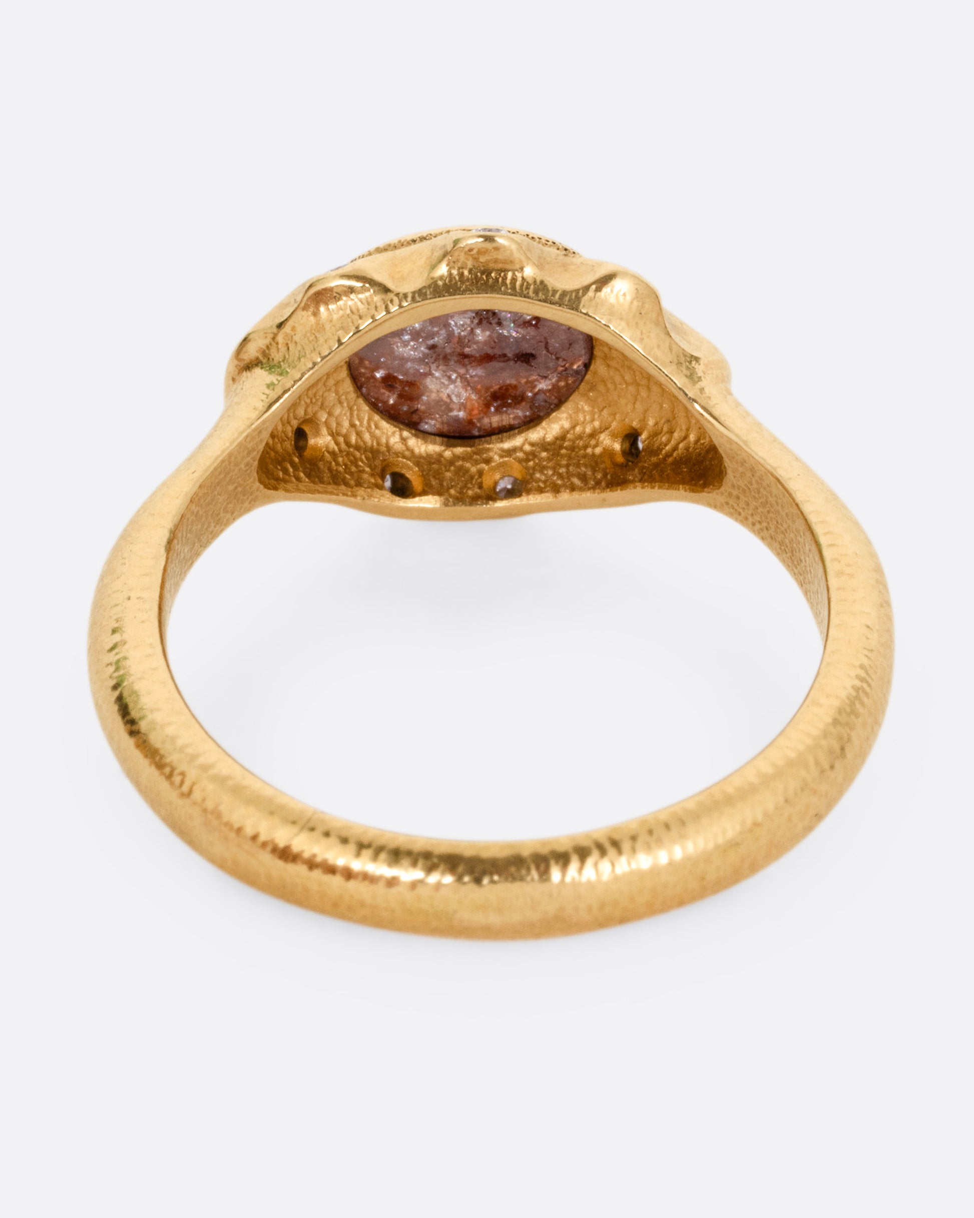 A yellow gold ring with a brown diamond and white diamond accents, shown from the back.