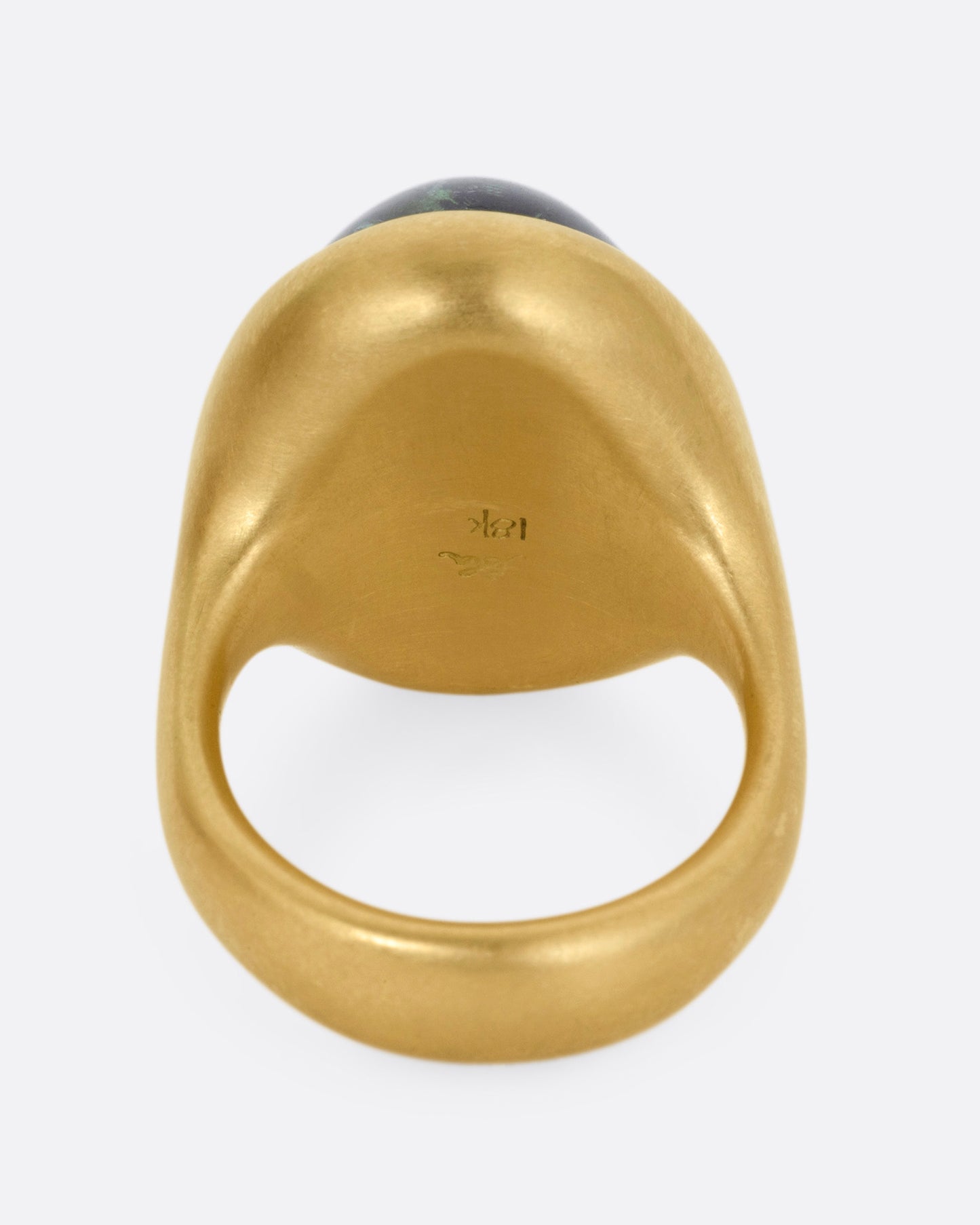 A yellow gold ring with a green tourmaline cabochon, shown from the back.