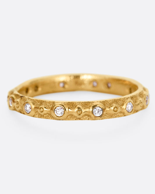 A textured yellow gold ring with white diamonds. Shown from the front.