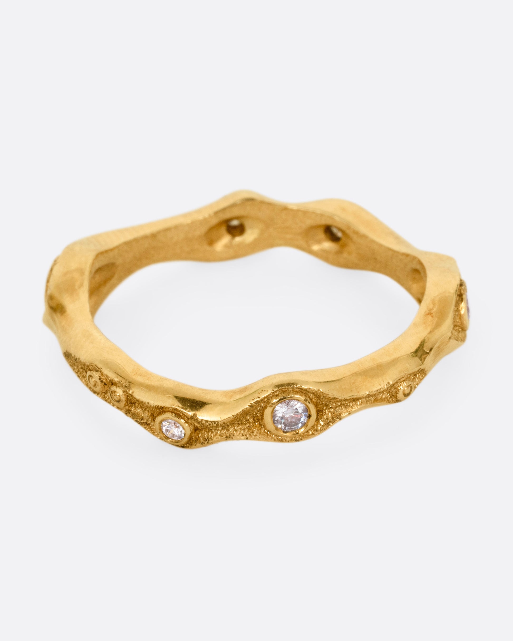 A textured yellow gold ring with white diamonds. Shown from the front.