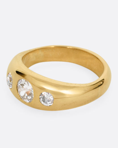 A yellow gold ring with three diamonds, shown from the side.