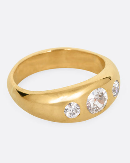 A yellow gold ring with three diamonds, shown from the side.