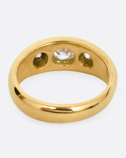 A yellow gold ring with three diamonds, shown from the back.