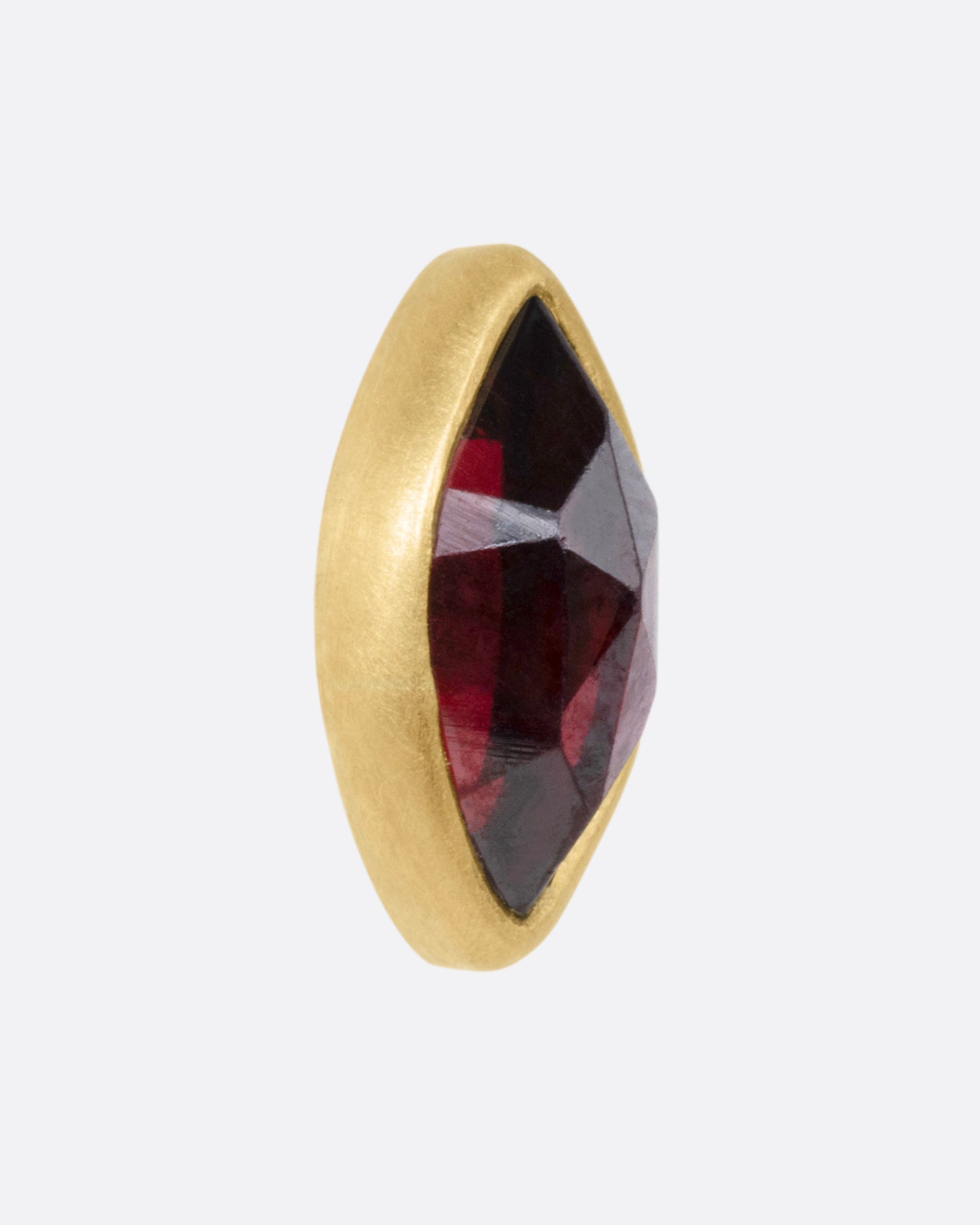 A yellow gold navette garnet earring, shown from the side.
