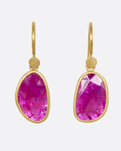 Yellow gold ruby drop earrings, the pair from the front showing the bright pink-red rubies