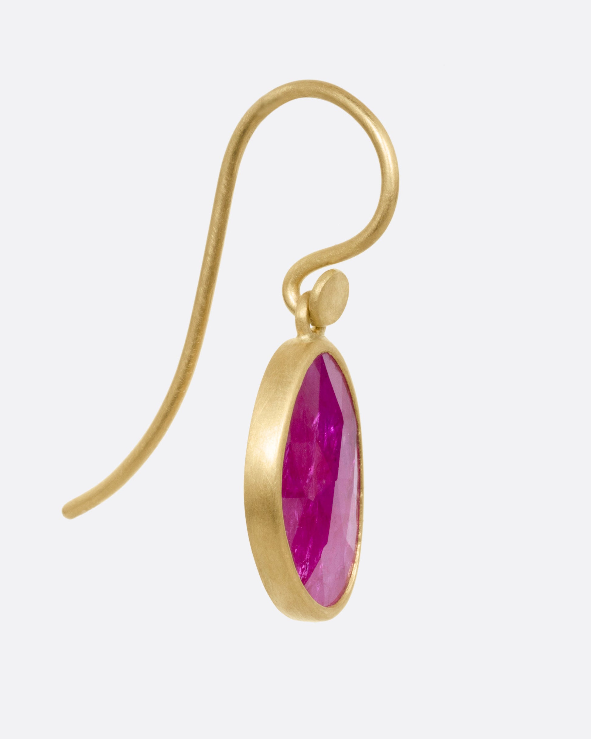A yellow gold drop earring with a Mozambique ruby, shown from the side.