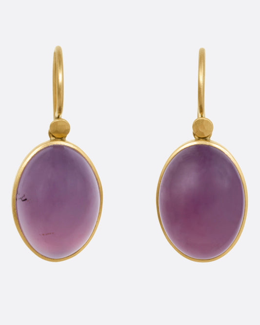 A pair of yellow gold earrings with purple chalcedony drops, shown from the front.