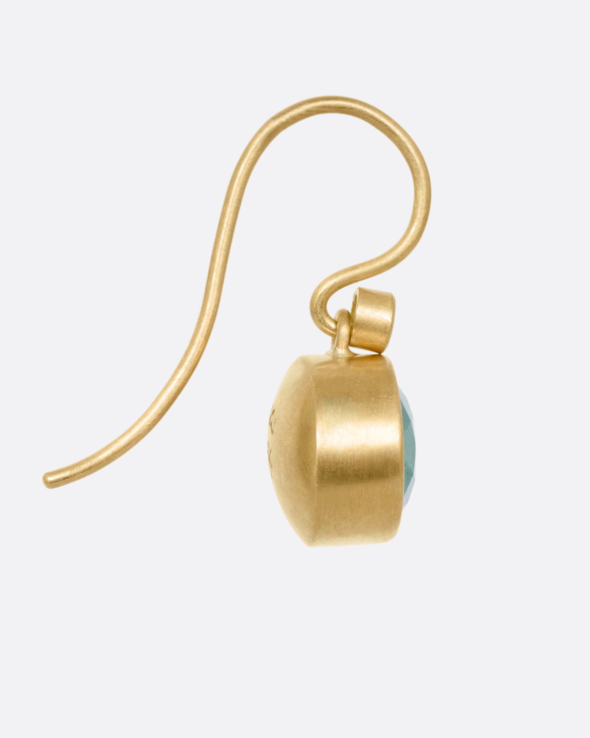 A yellow gold drop earring with a Colombian emerald and a diamond accent, shown from the side.