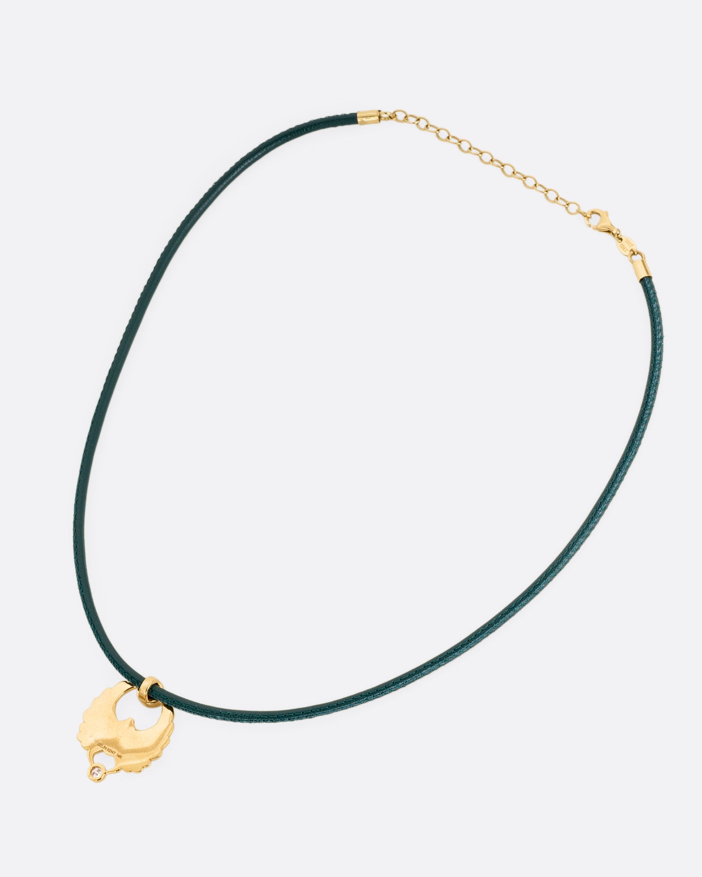 A yellow gold scarab pendant with a ruby and diamond, suspended from a green leather choker cord. Shown from the back.