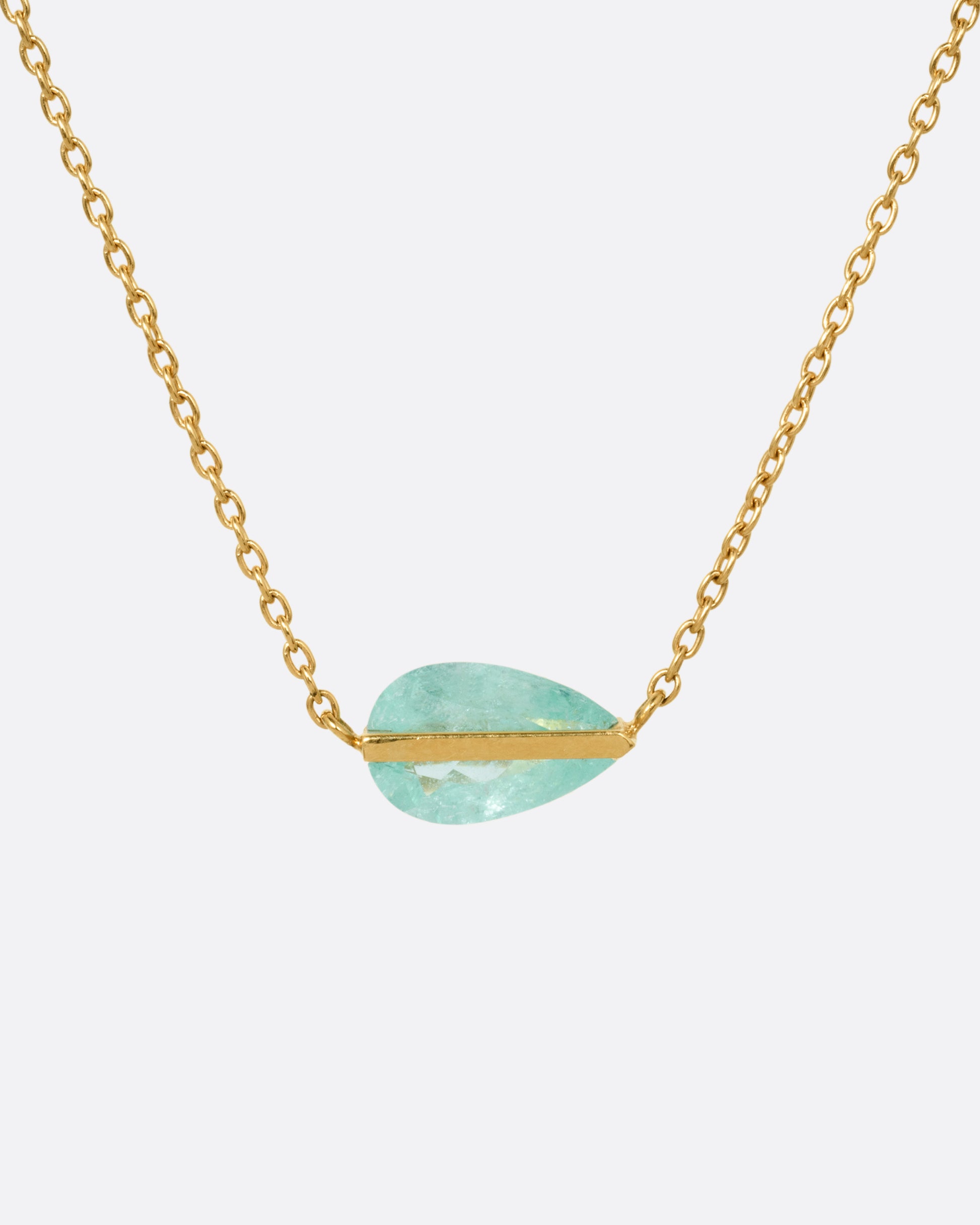 A yellow gold cable chain necklace with a blue-green Paraiba tourmaline pendant, shown from the front.