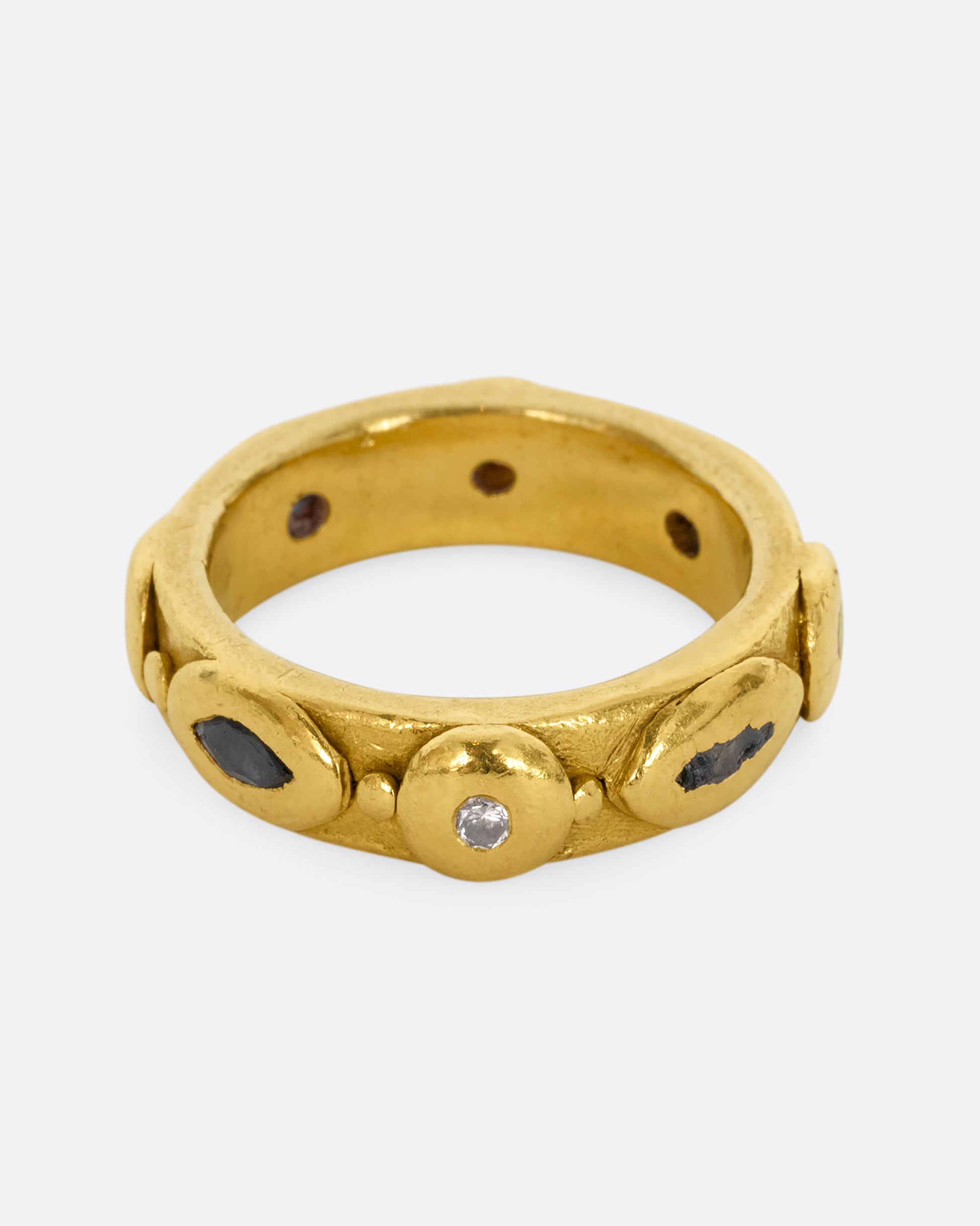 A high karat yellow gold ring with marquis blue sapphires and round diamonds all the way around.