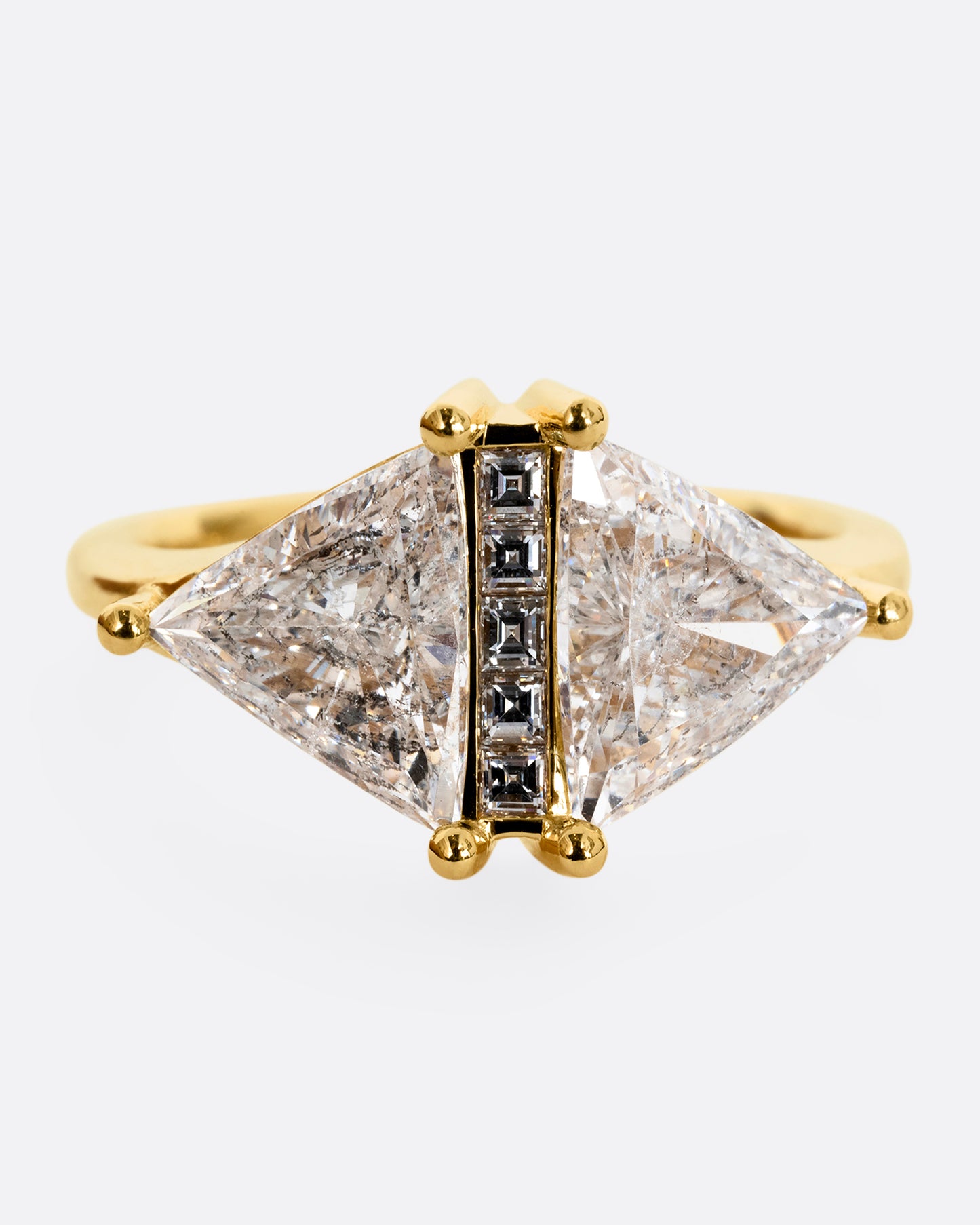 A yellow gold ring with two salt and pepper trillion cut diamonds and diamond accents. Shown from the front, close up.