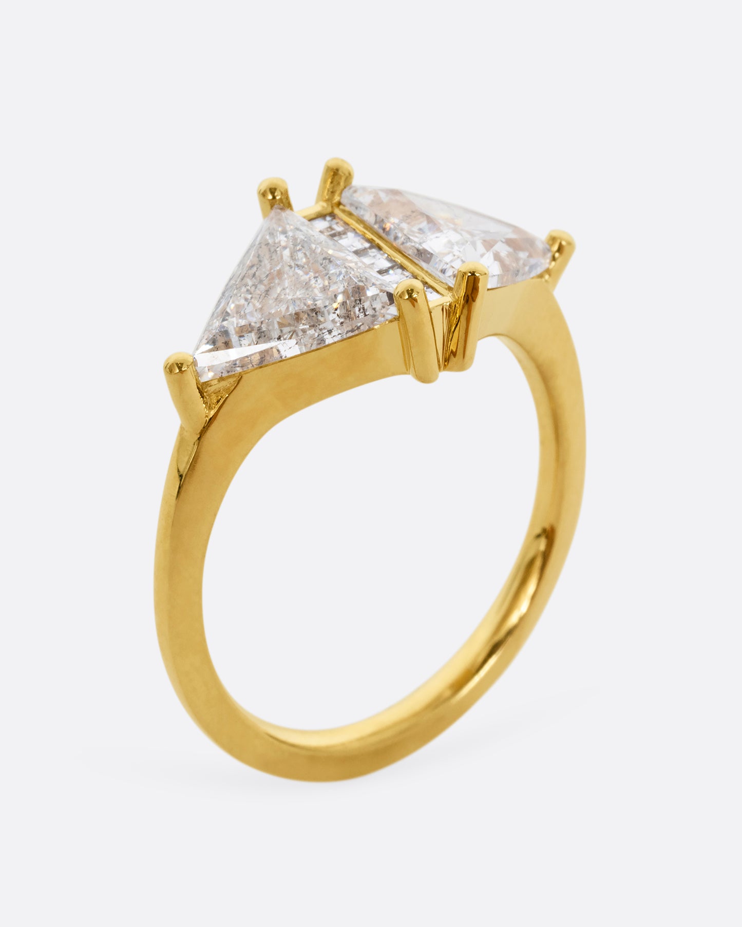 A yellow gold ring with two salt and pepper trillion cut diamonds and diamond accents. Shown from the side, standing up.