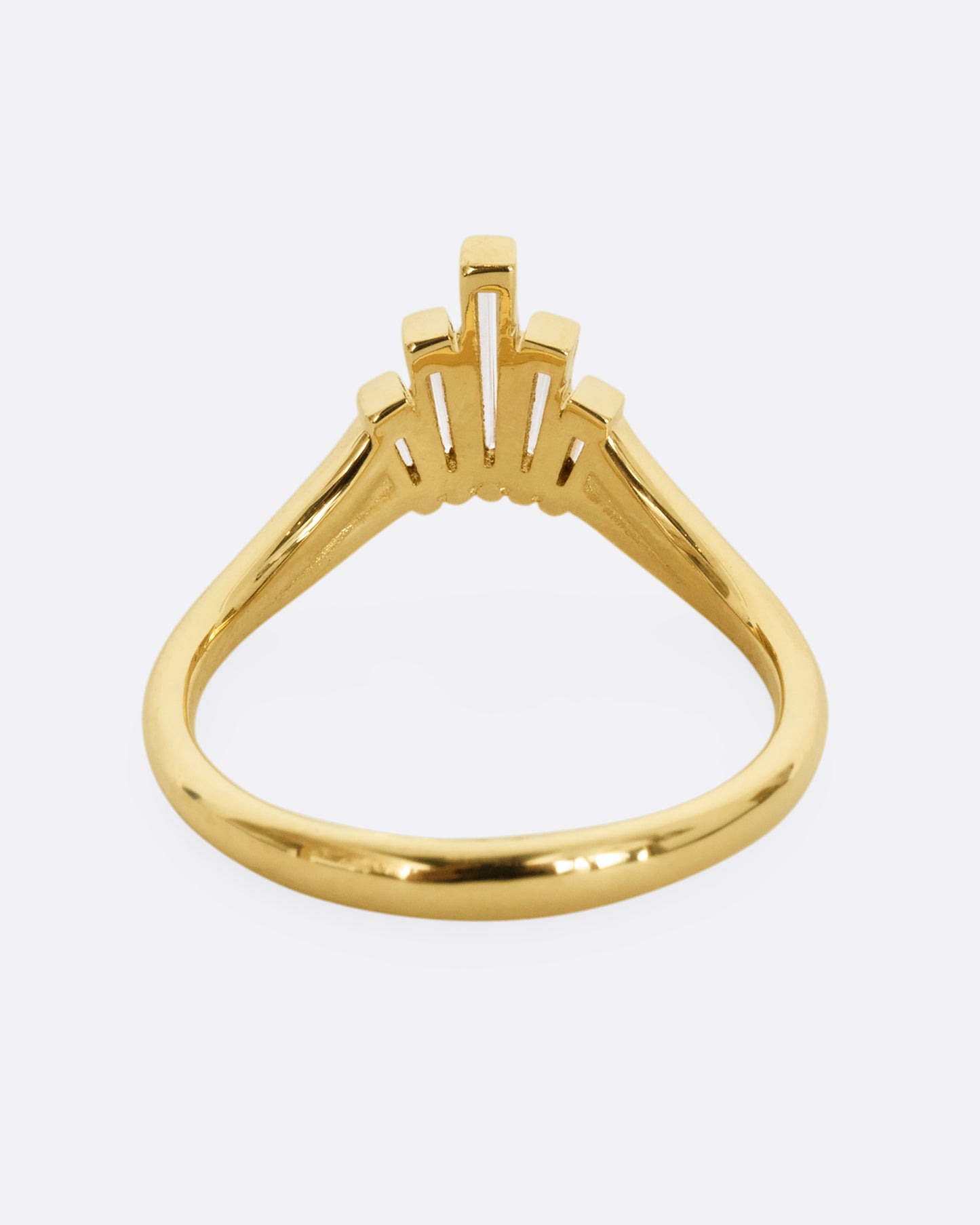 A yellow gold ring with graduated baguette diamonds. Shown from the back.