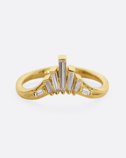 A yellow gold ring with graduated baguette diamonds. Shown from the front.