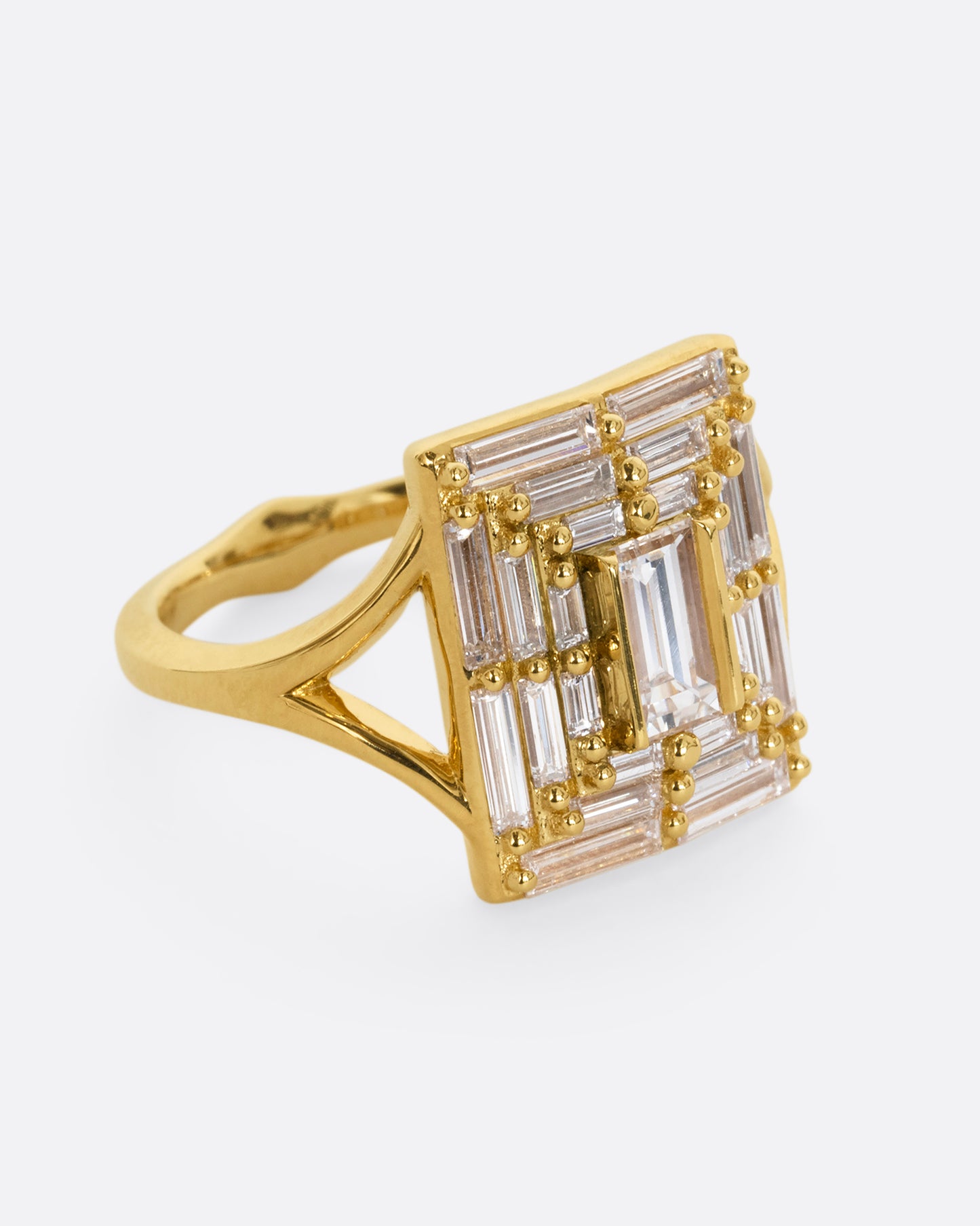 A yellow gold ring with a mosaic of white diamonds in the shape of a square. Shown from the side.