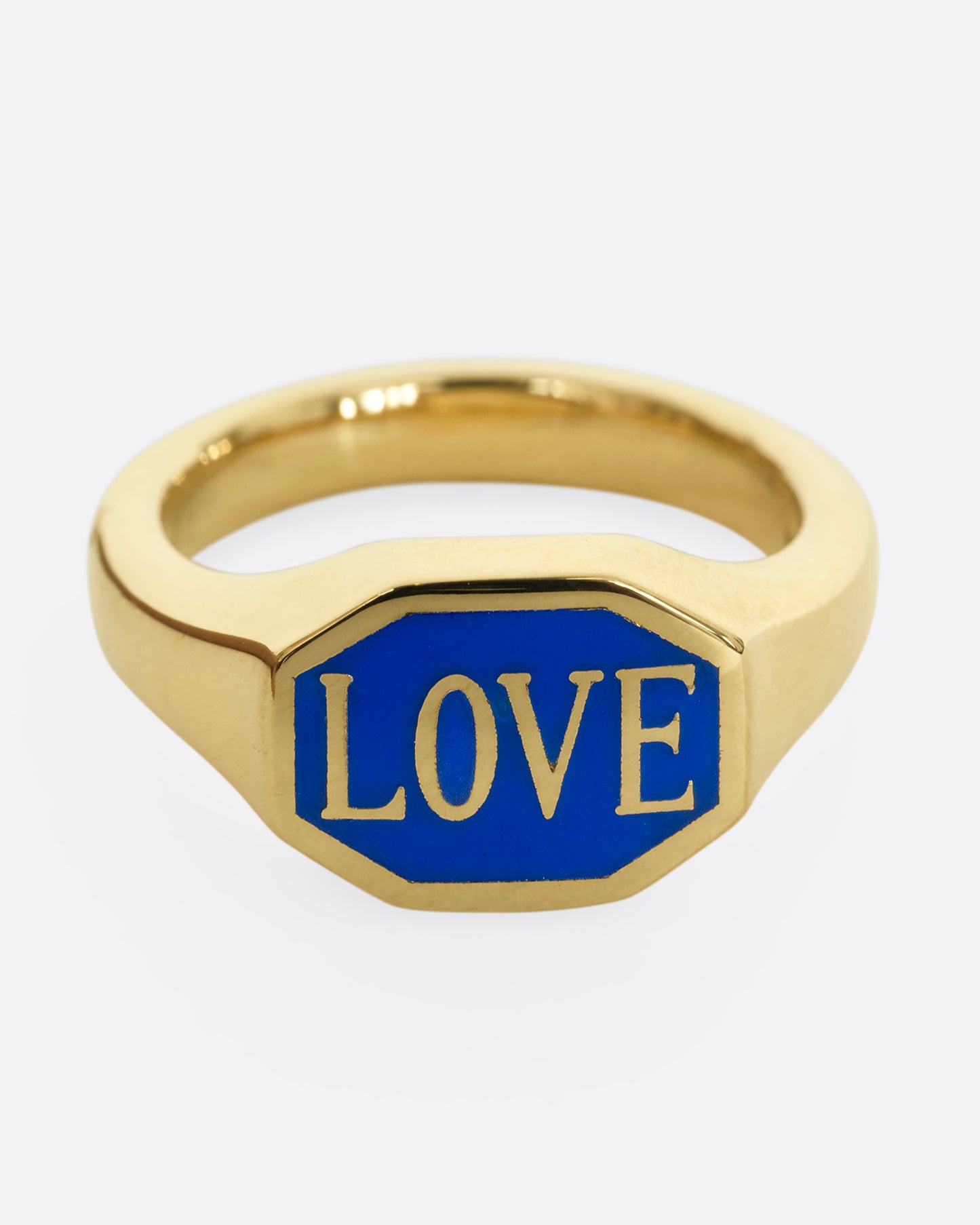 A yellow gold signet ring with blue enameled face with the word "Love". Shown from the front.