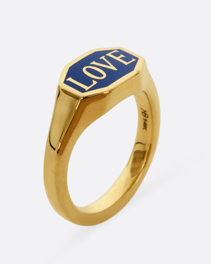 A yellow gold signet ring with blue enameled face with the word "Love". Shown from the side, standing.