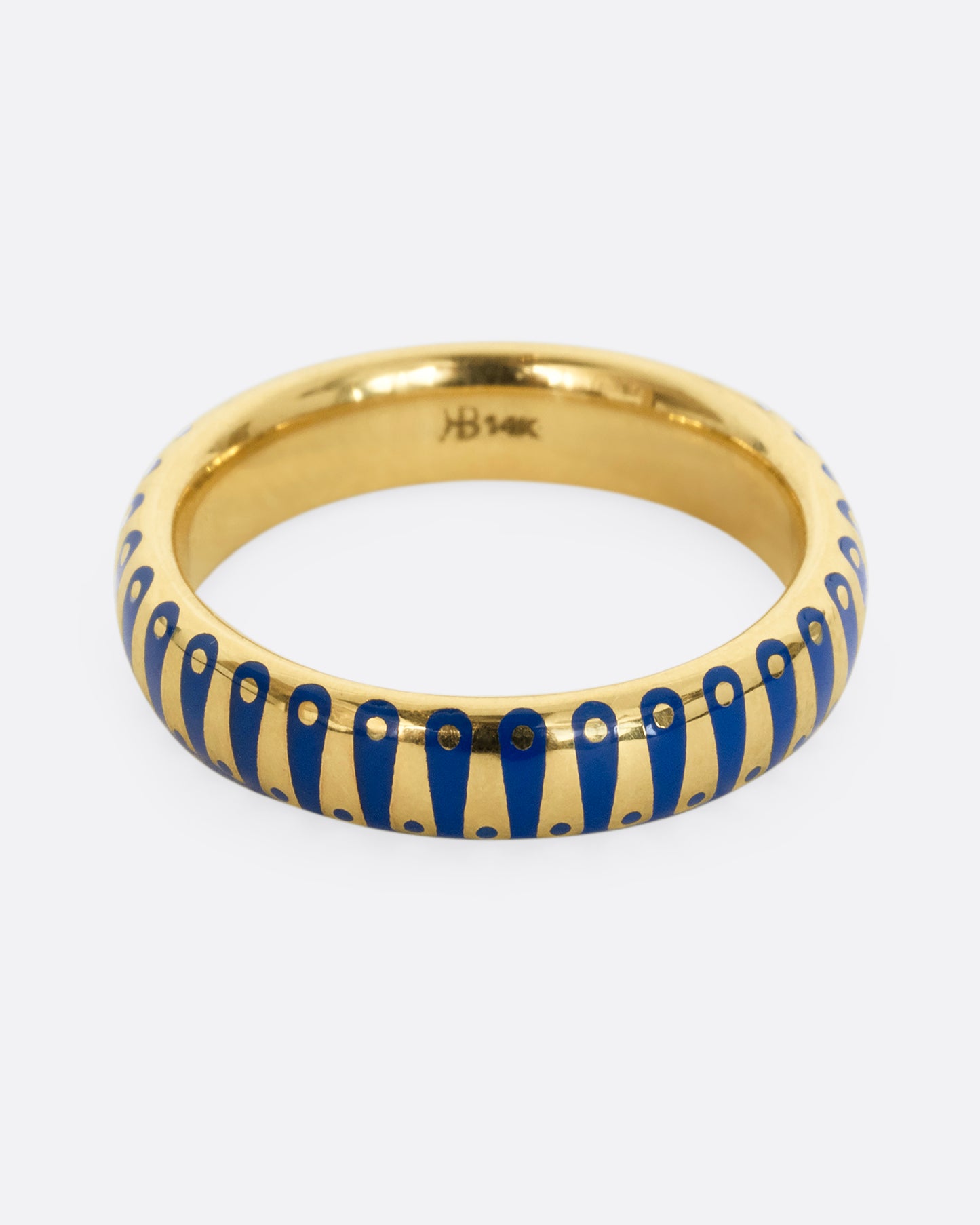 A yellow gold band ring with cobalt blue enamel stripes and dots. Shown from the front.