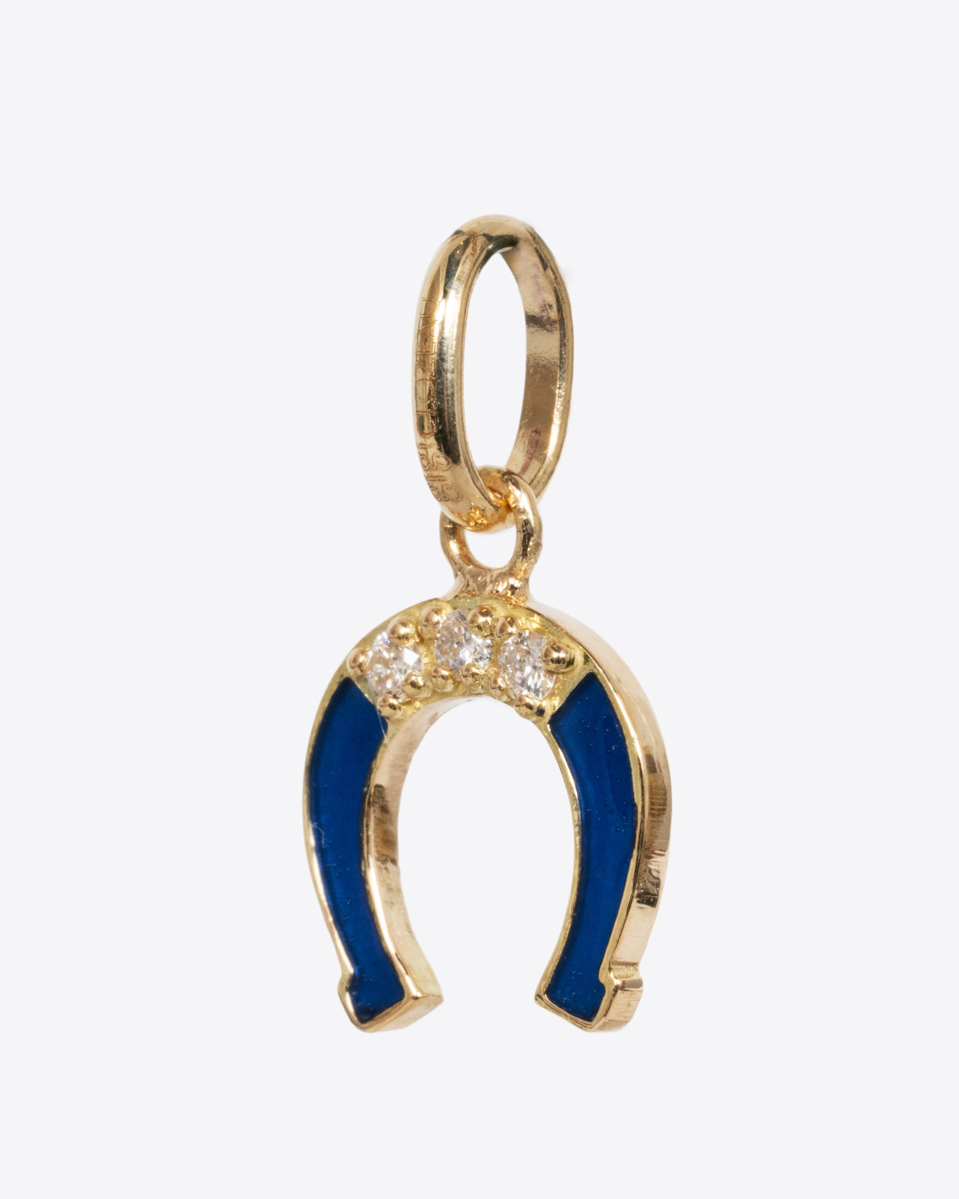 A yellow gold horseshoe charm with lapis blue enamel and white diamonds. Shown from the side.