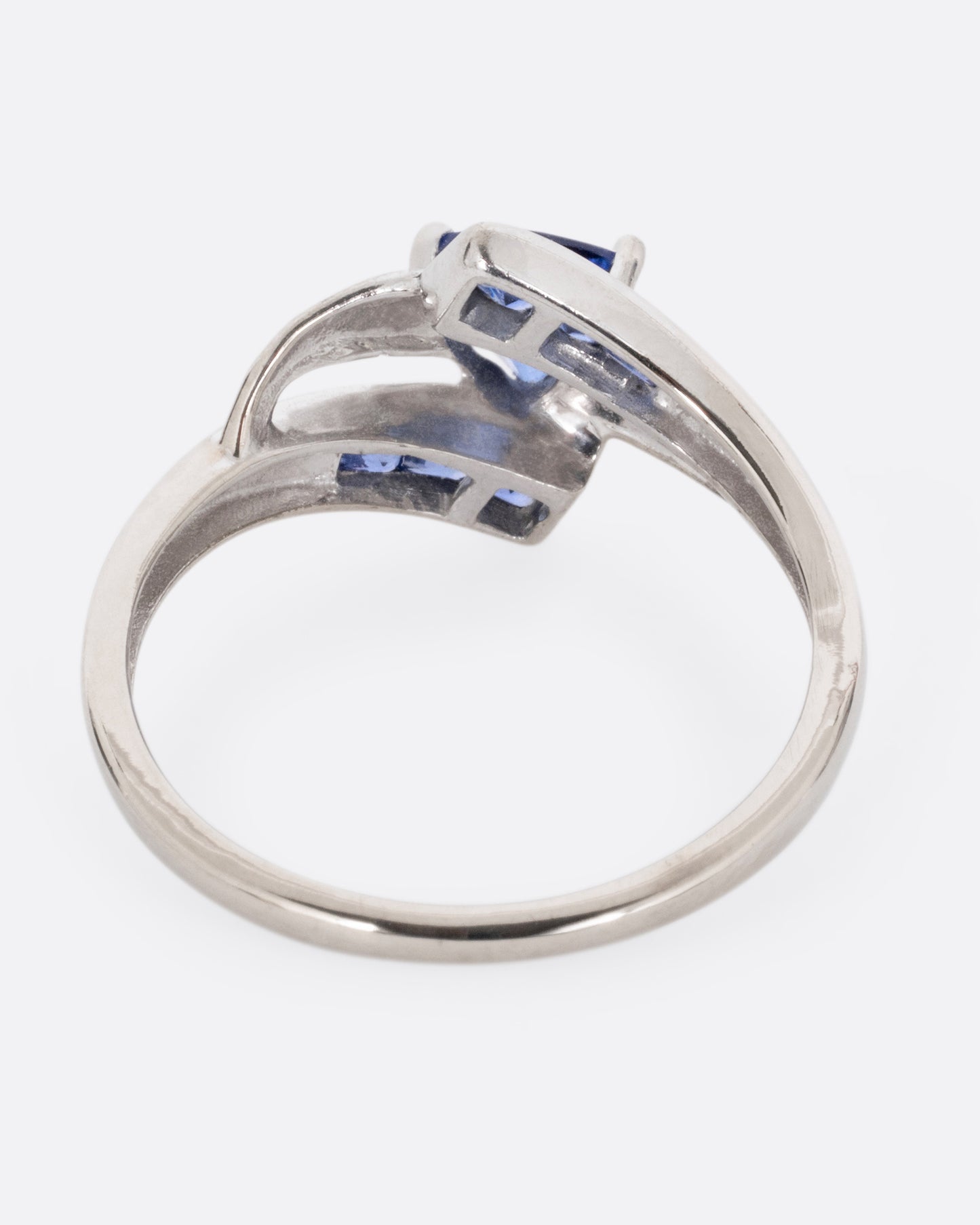 A white gold wrap wring with diamonds and sapphires, shown from the back.