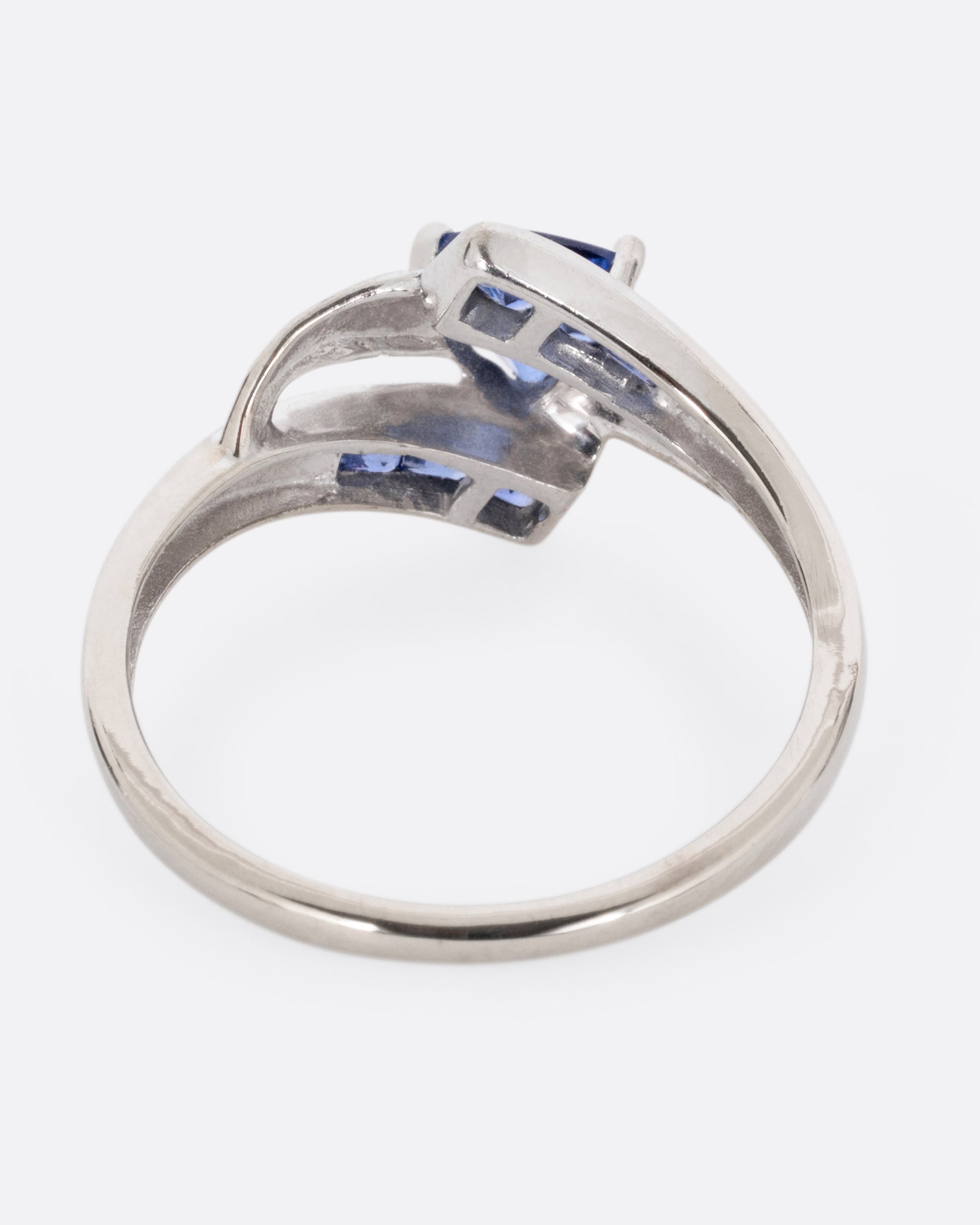 A white gold wrap wring with diamonds and sapphires, shown from the back.
