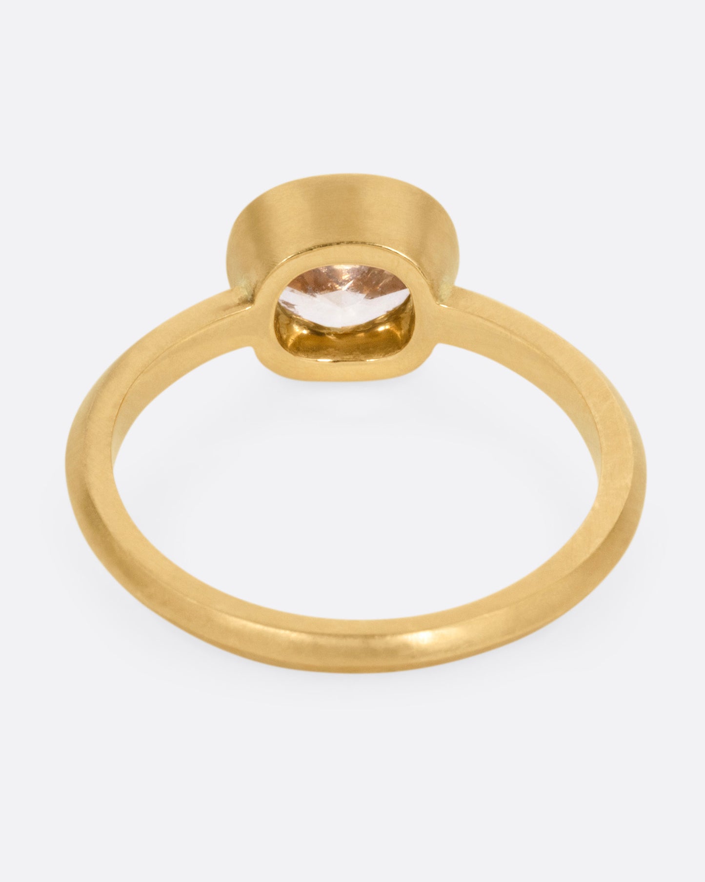 A yellow gold ring with a cognac diamond, shown from the back.