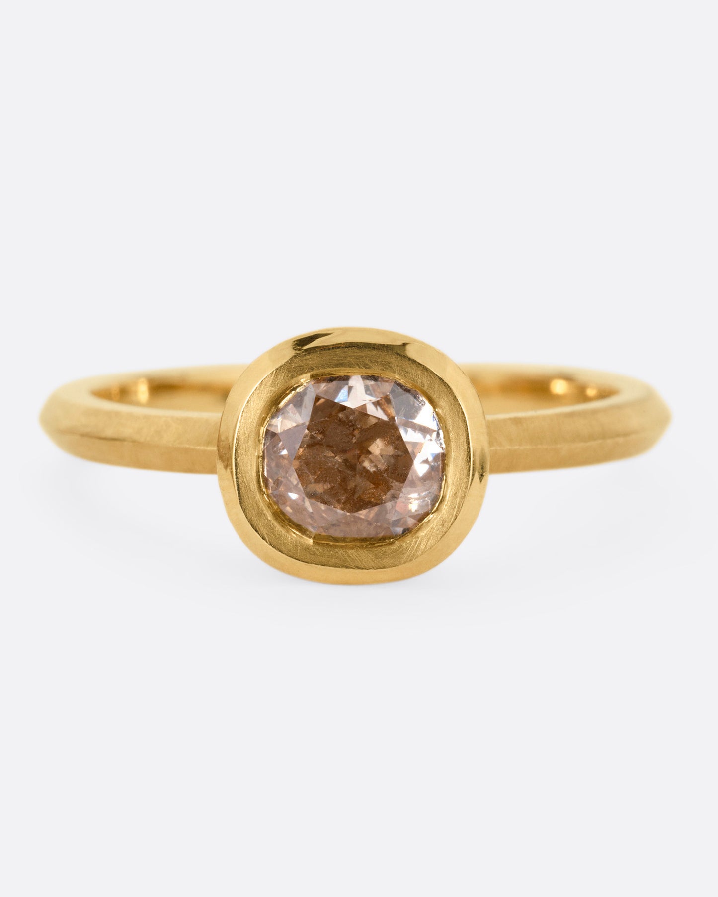 A yellow gold ring with a cognac diamond, shown from the front.