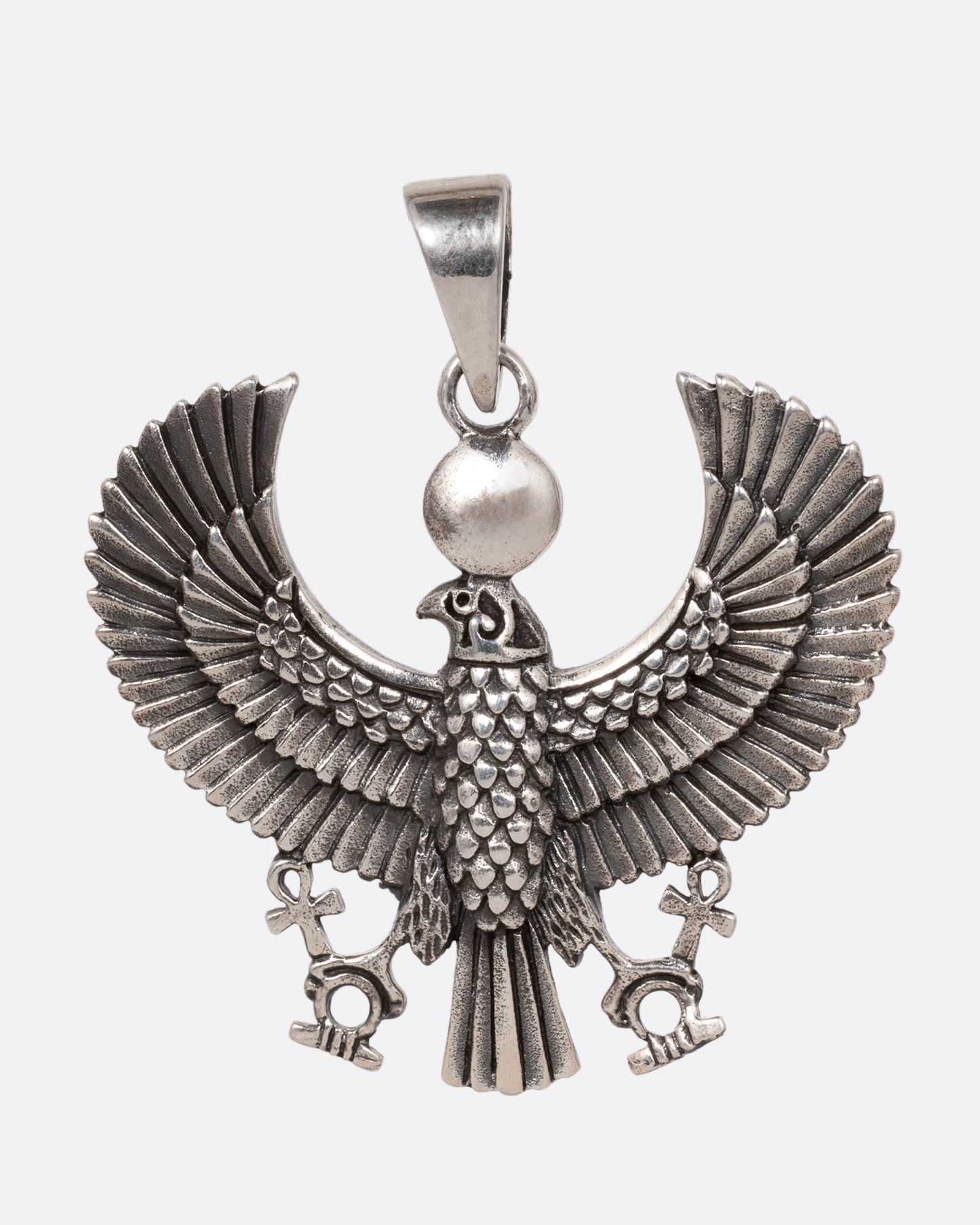 A silver pendant depicting the ancient Egyptian god, Horus, in falcon form, shown from the front. 