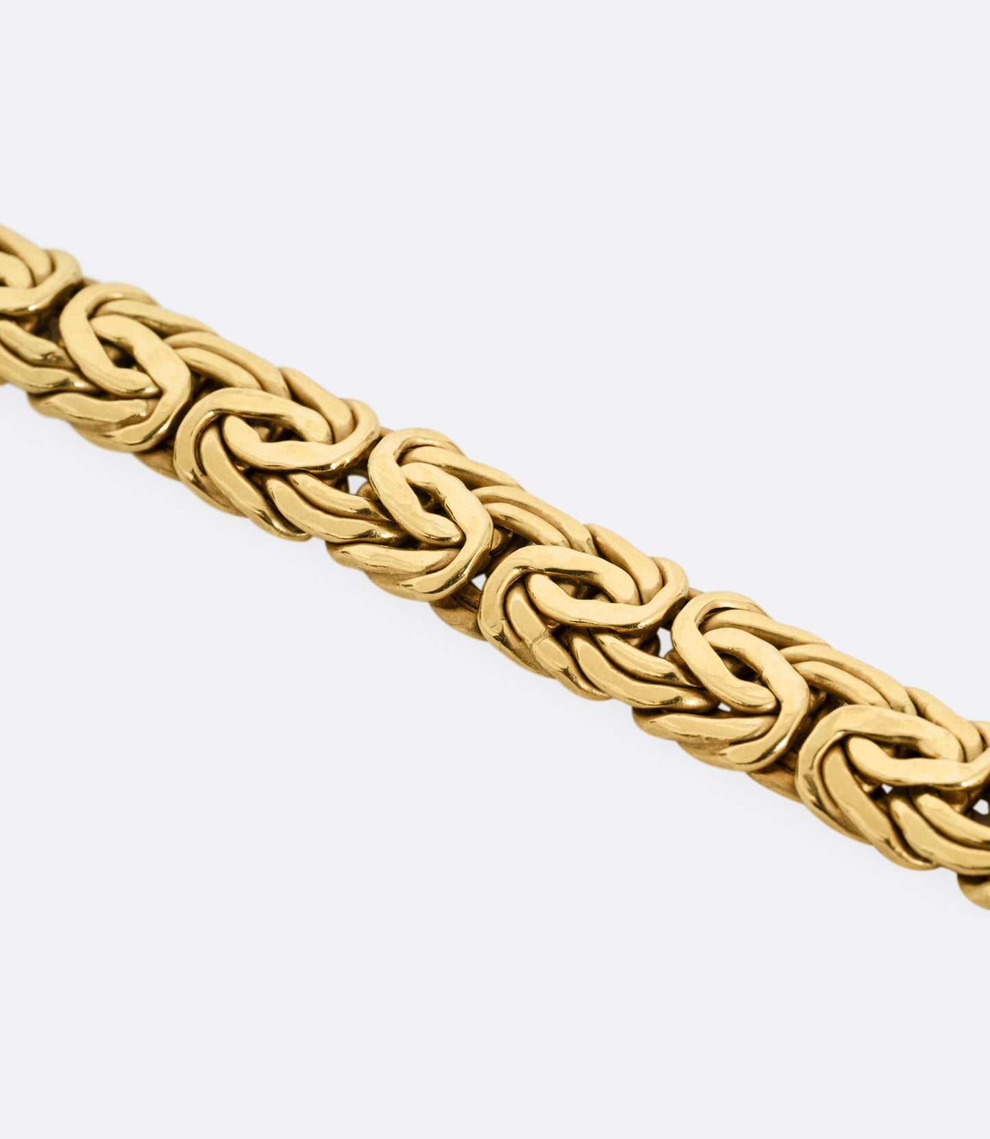 A close up of a yellow gold byzantine chain bracelet.