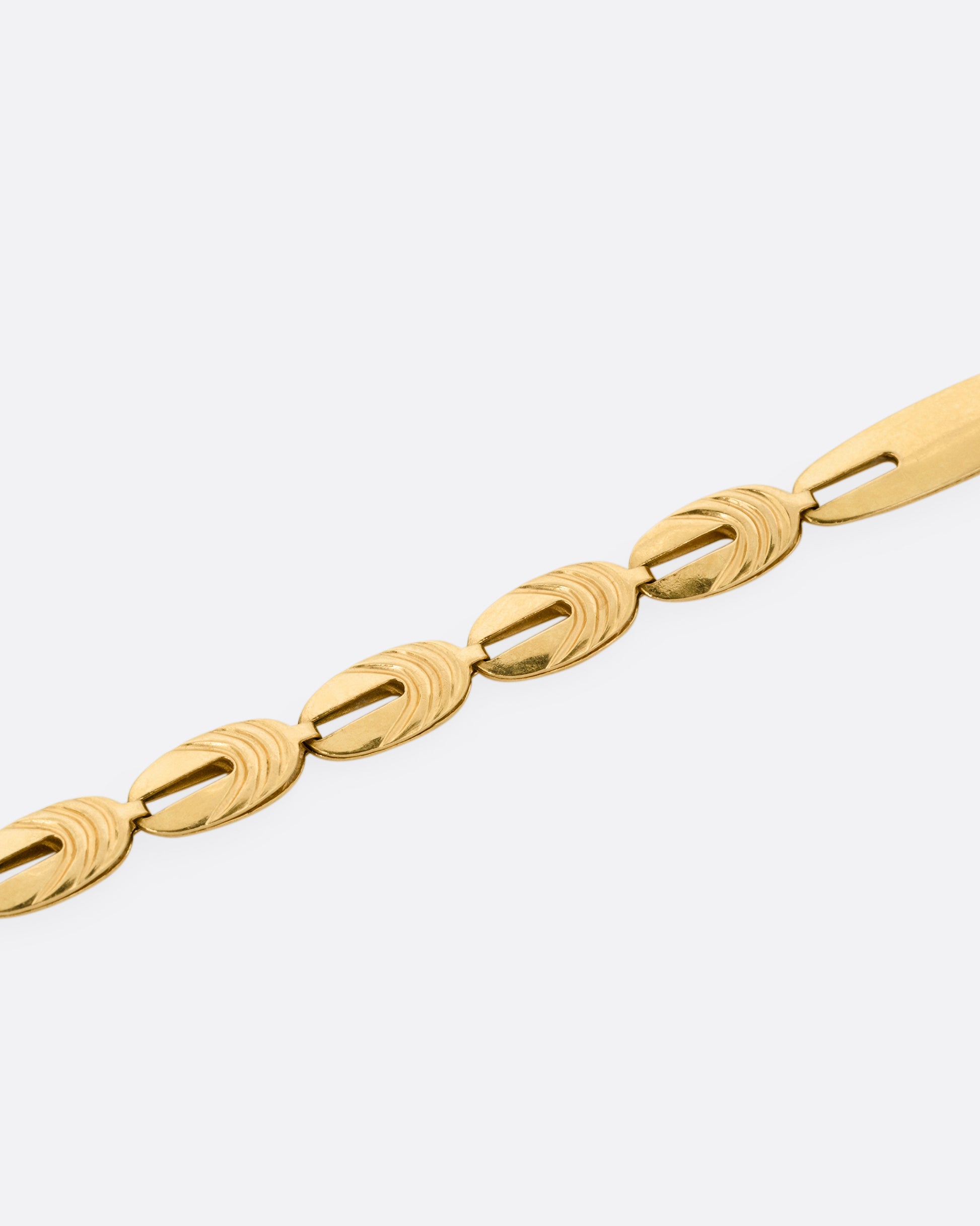 A close up of a yellow gold oval link bracelet.