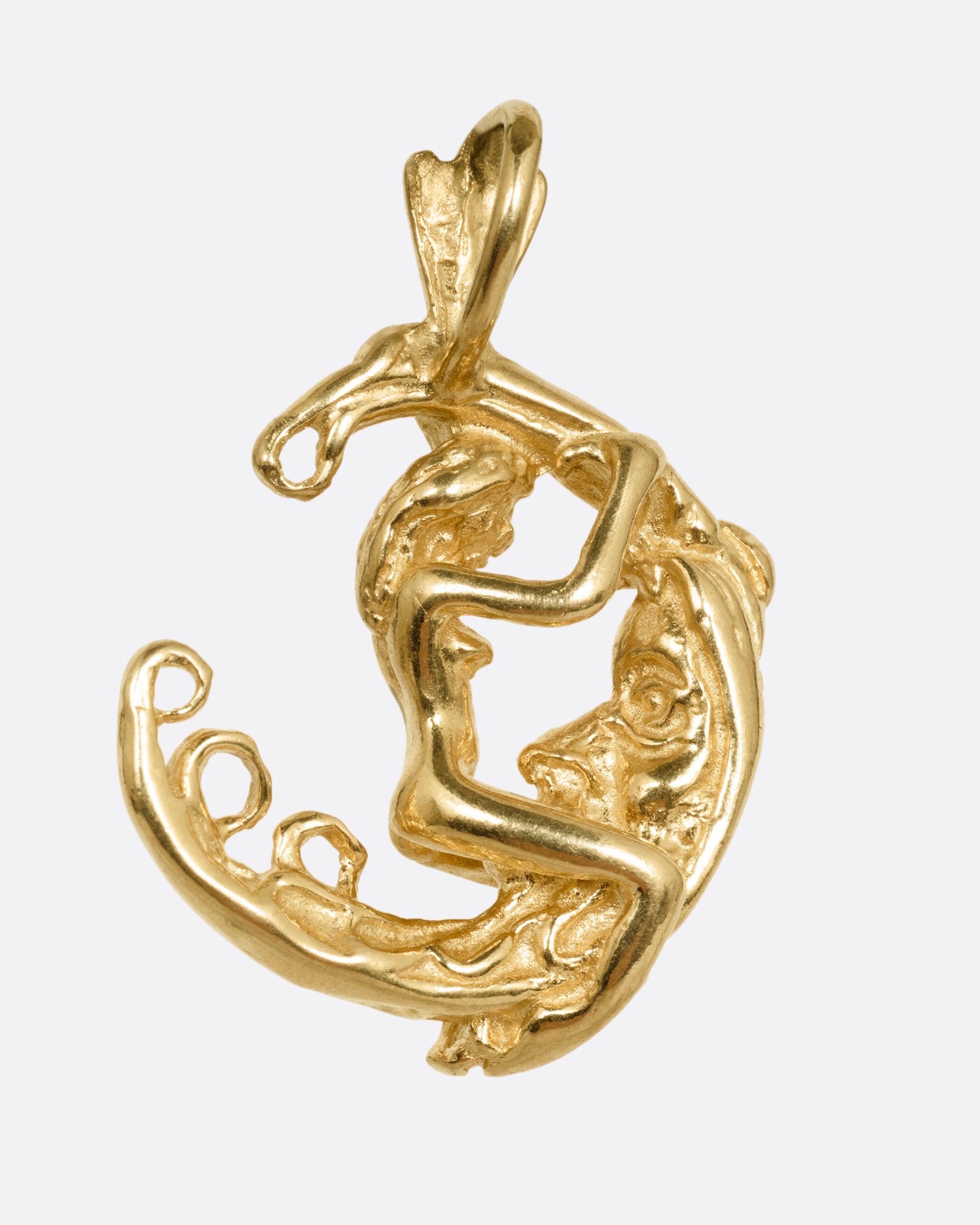 A yellow gold pendant with a woman astride a crescent moon. Shown from the back.
