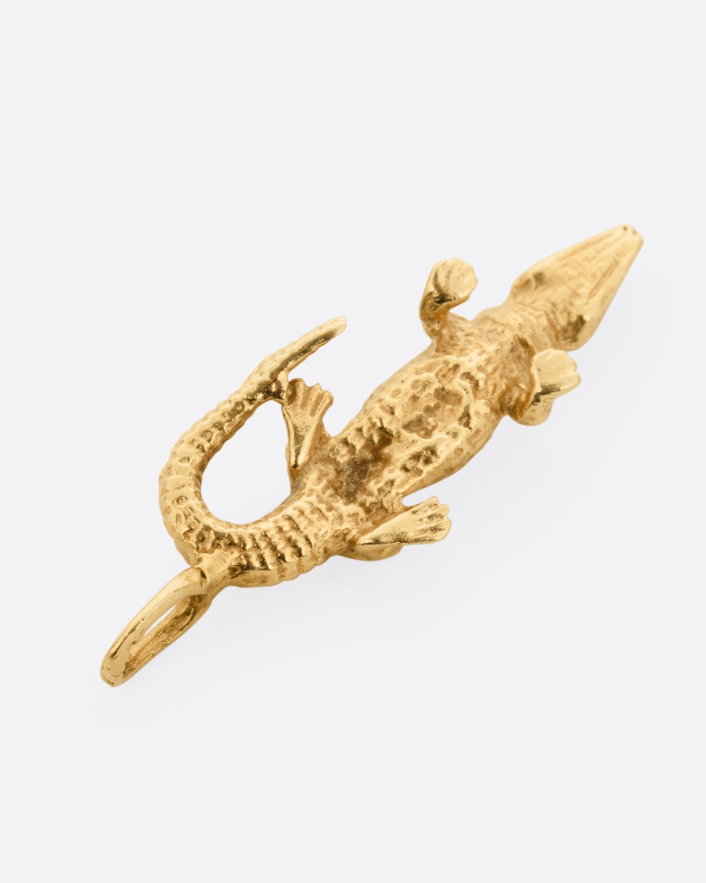 A yellow gold alligator charm, shown from the back.