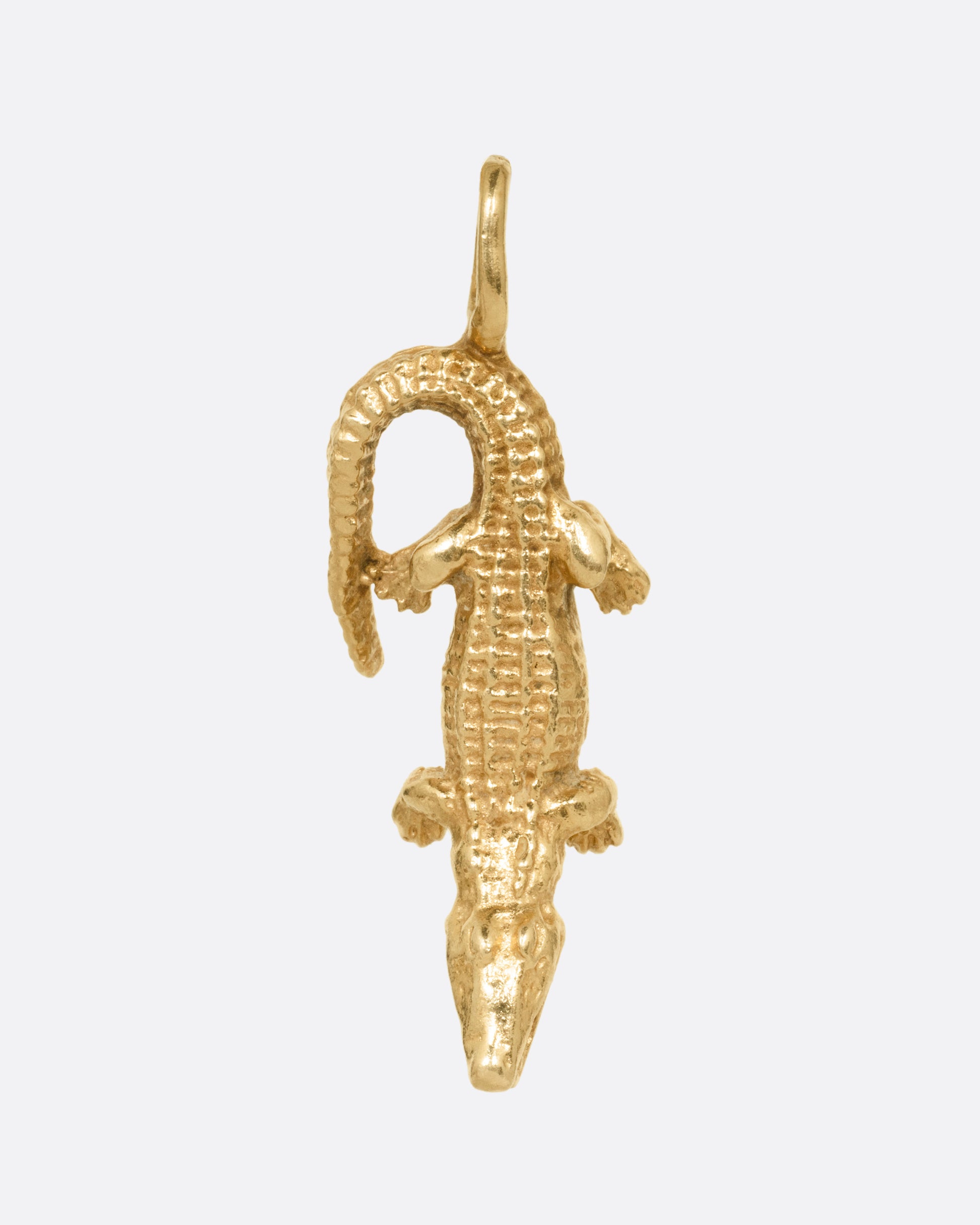 A yellow gold alligator charm, shown from the front.