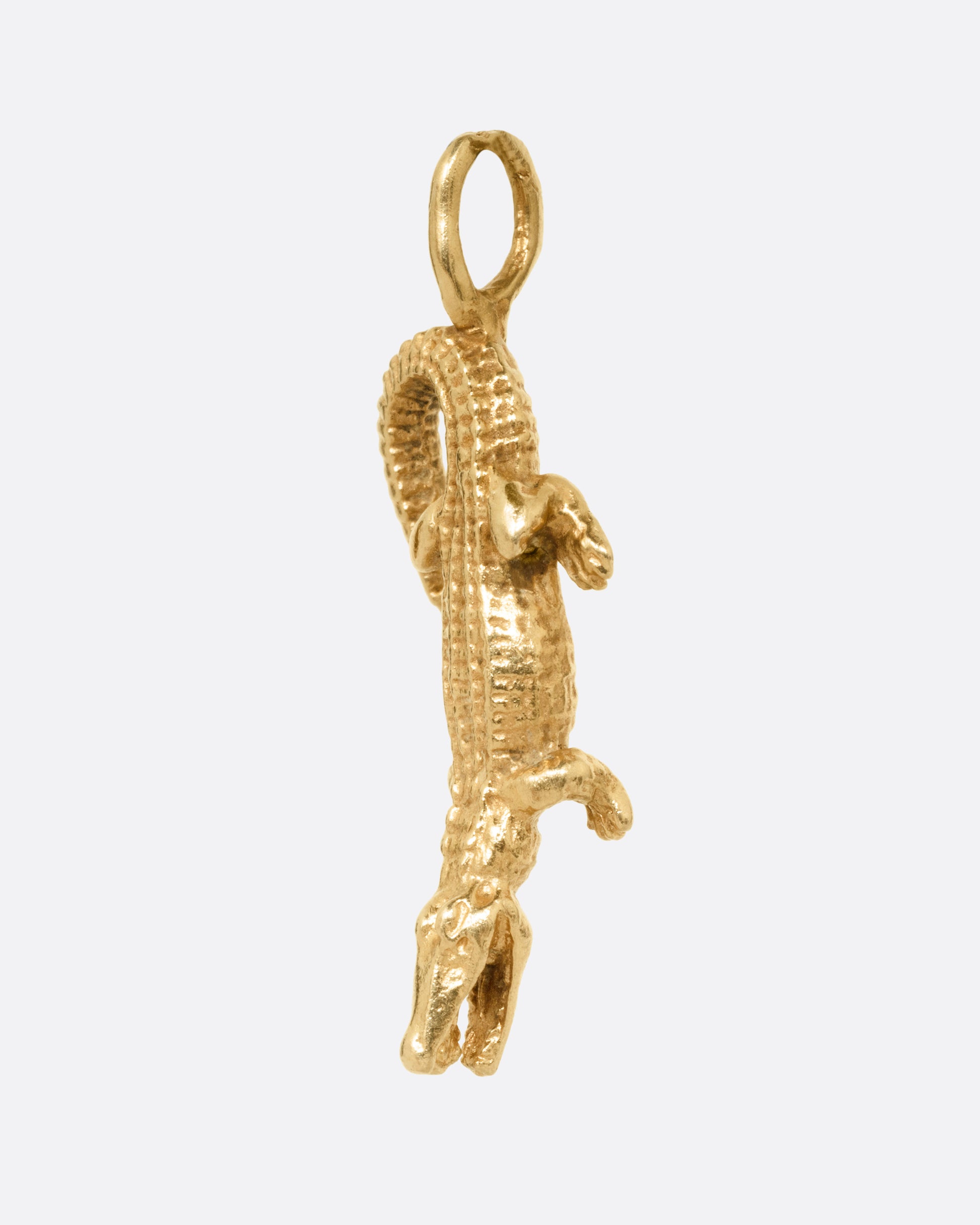 A yellow gold alligator charm, shown from the side.