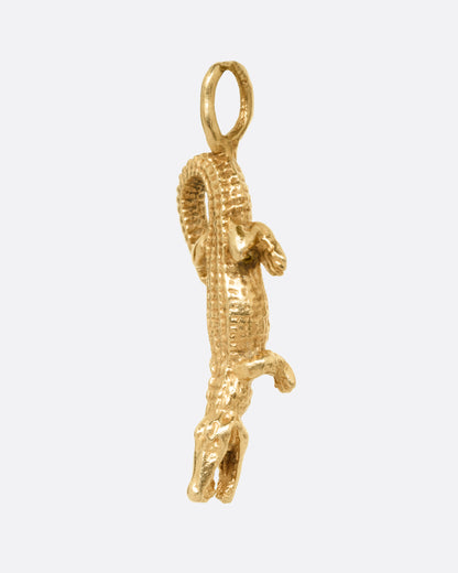 A yellow gold alligator charm, shown from the side.