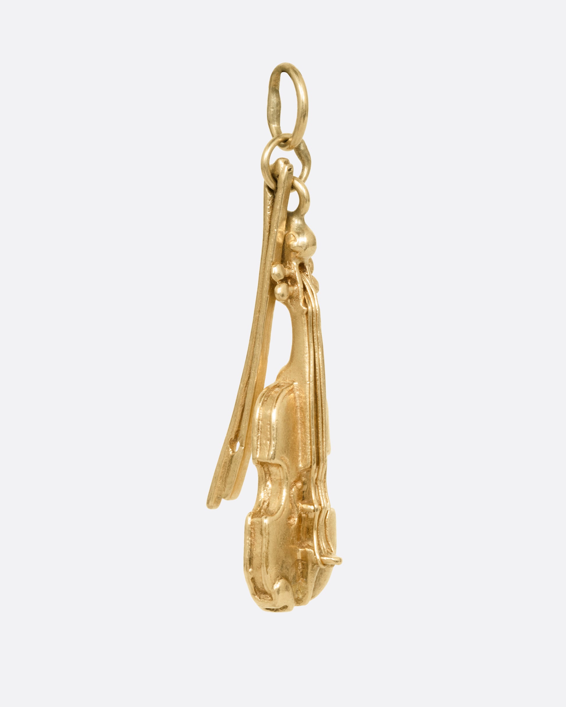 A yellow gold violin and bow charm, shown from the side.