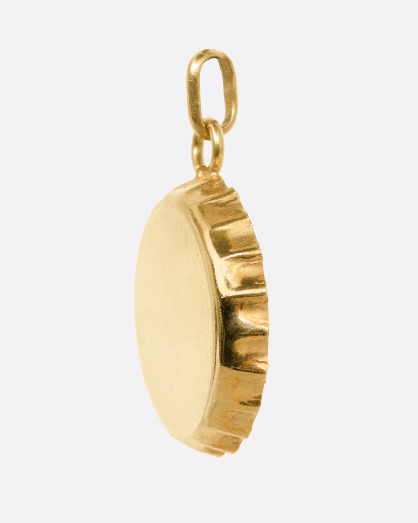 A yellow gold bottle cap charm, shown from the side.