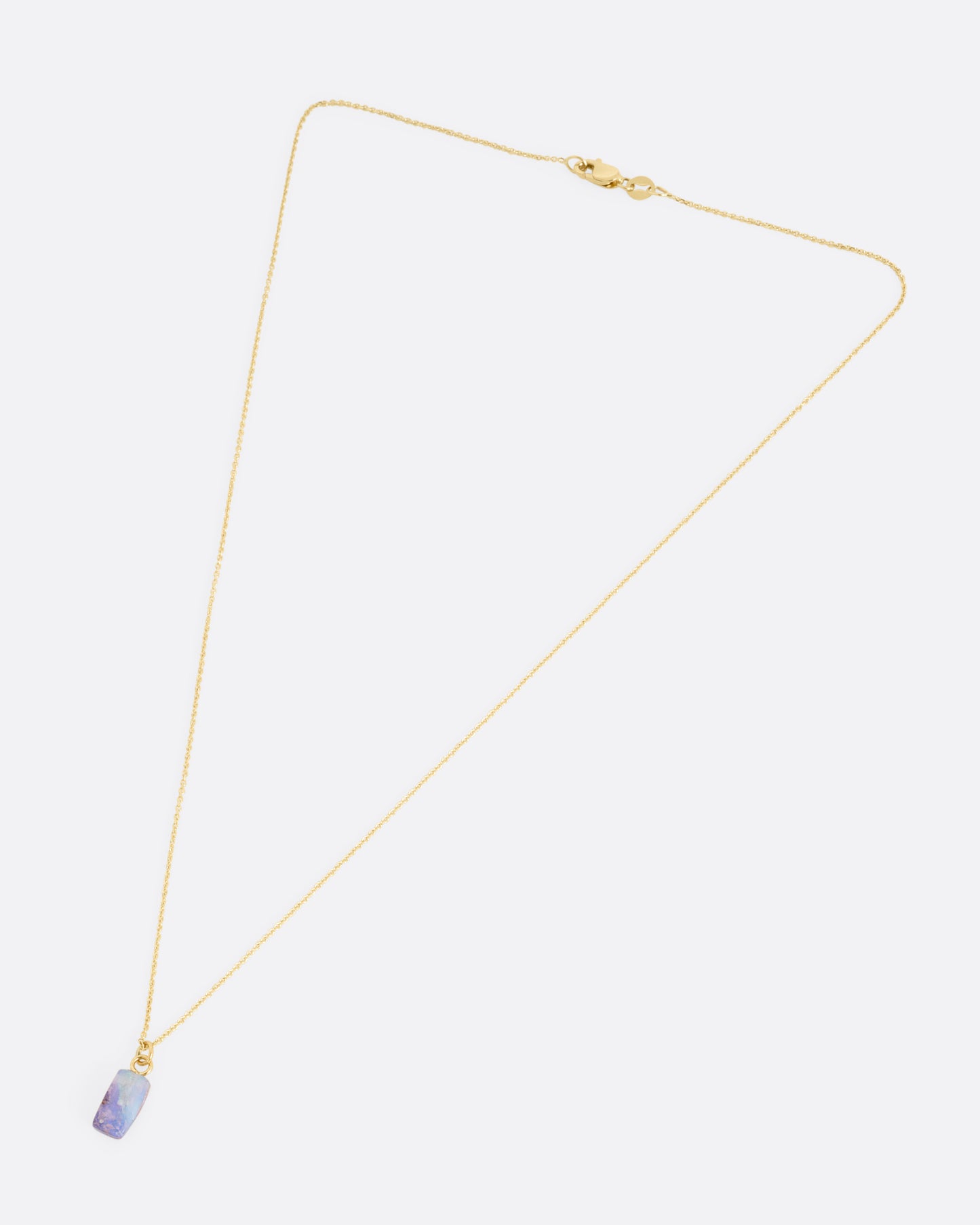 A yellow gold cable chain necklace with a fossilized Australian opal pendant. Shown from the front.