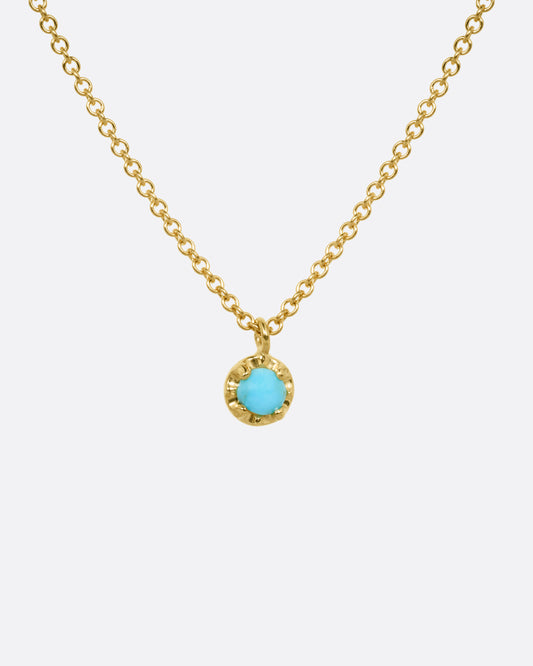 A yellow gold cable chain necklace with a  prong set turquoise, shown from the front.
